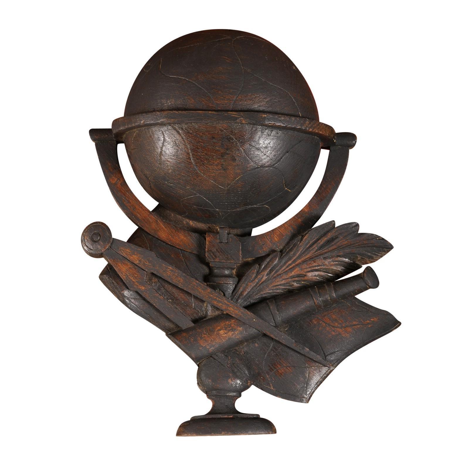 A French carved oak wall sculpture from the 19th century, depicting scientific instruments. Those instruments include a globe, compass, spyglass and quill. Embracing the intricate artistry of 19th-century French craftsmanship, this carved oak wall