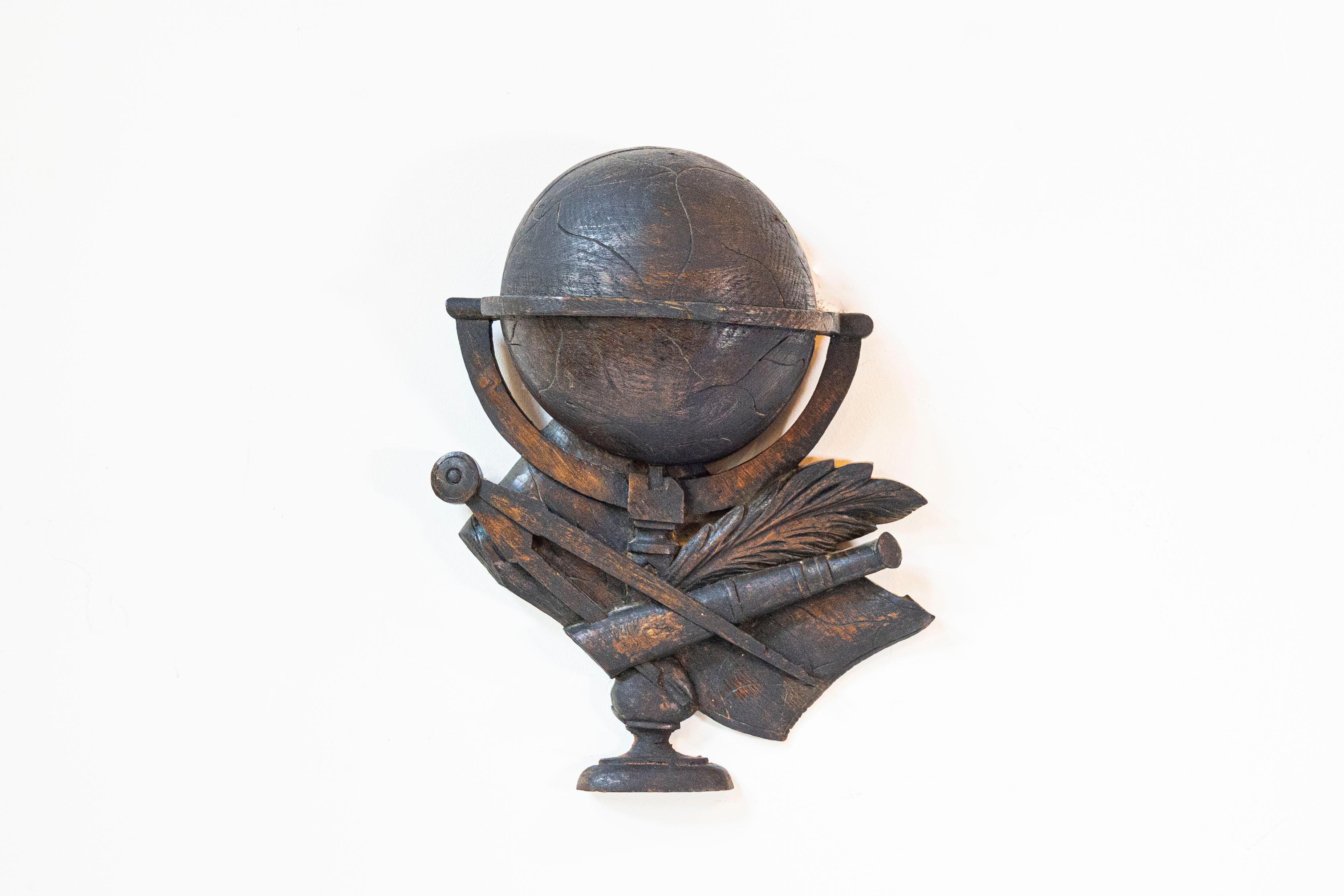 Sculpture murale en chêne français du XIXe siècle, représentant des instruments scientifiques. Ces instruments comprennent un globe, une boussole, une longue-vue et une plume d'oie. Cette sculpture murale en chêne est une ode captivante à l'époque