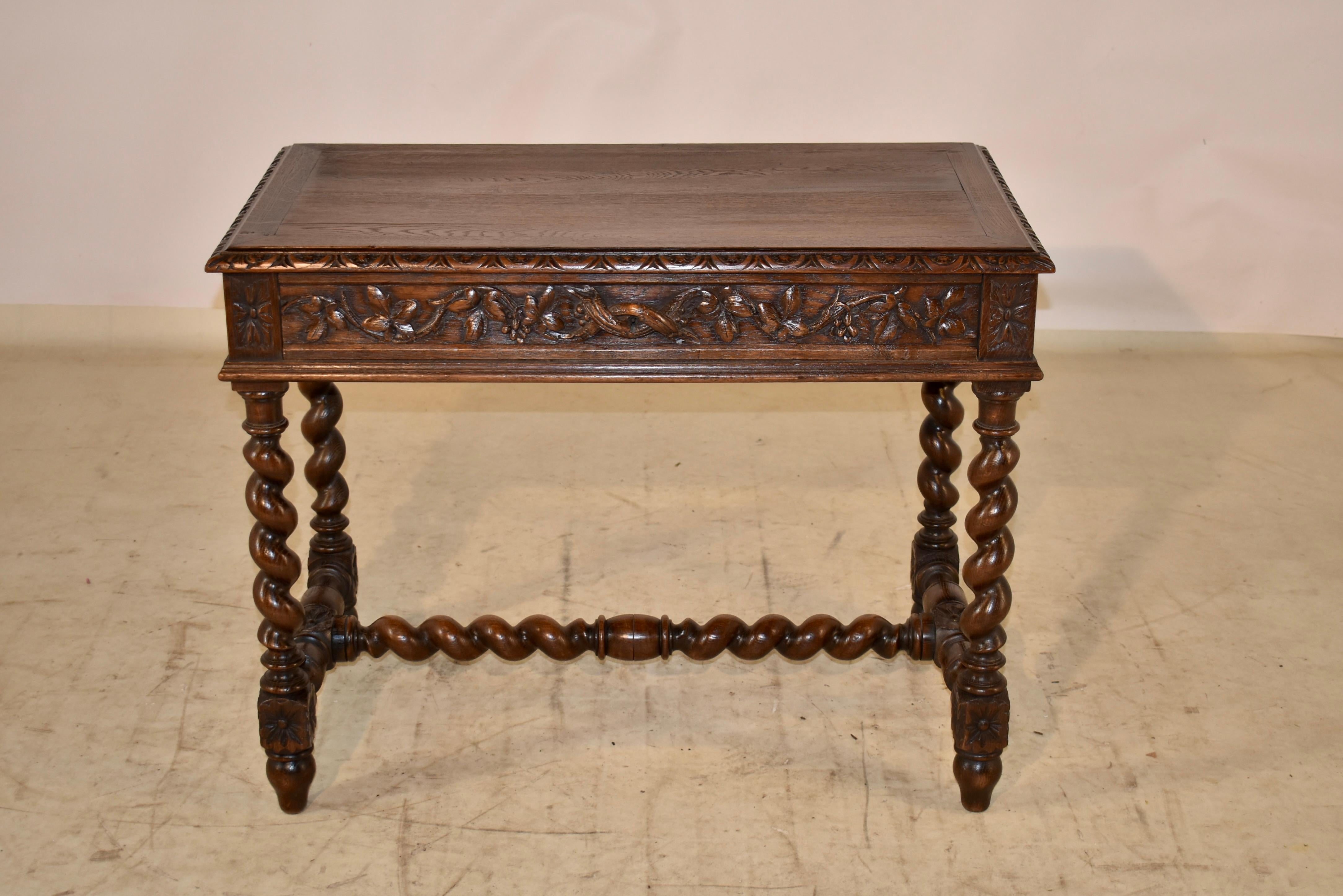 19th century Oak side or writing table from France. The top is banded and has a beveled and hand carved decorated edge. The apron is hand carved with leaves and vine decoration on all four sides for easy placement in any room. There is a single