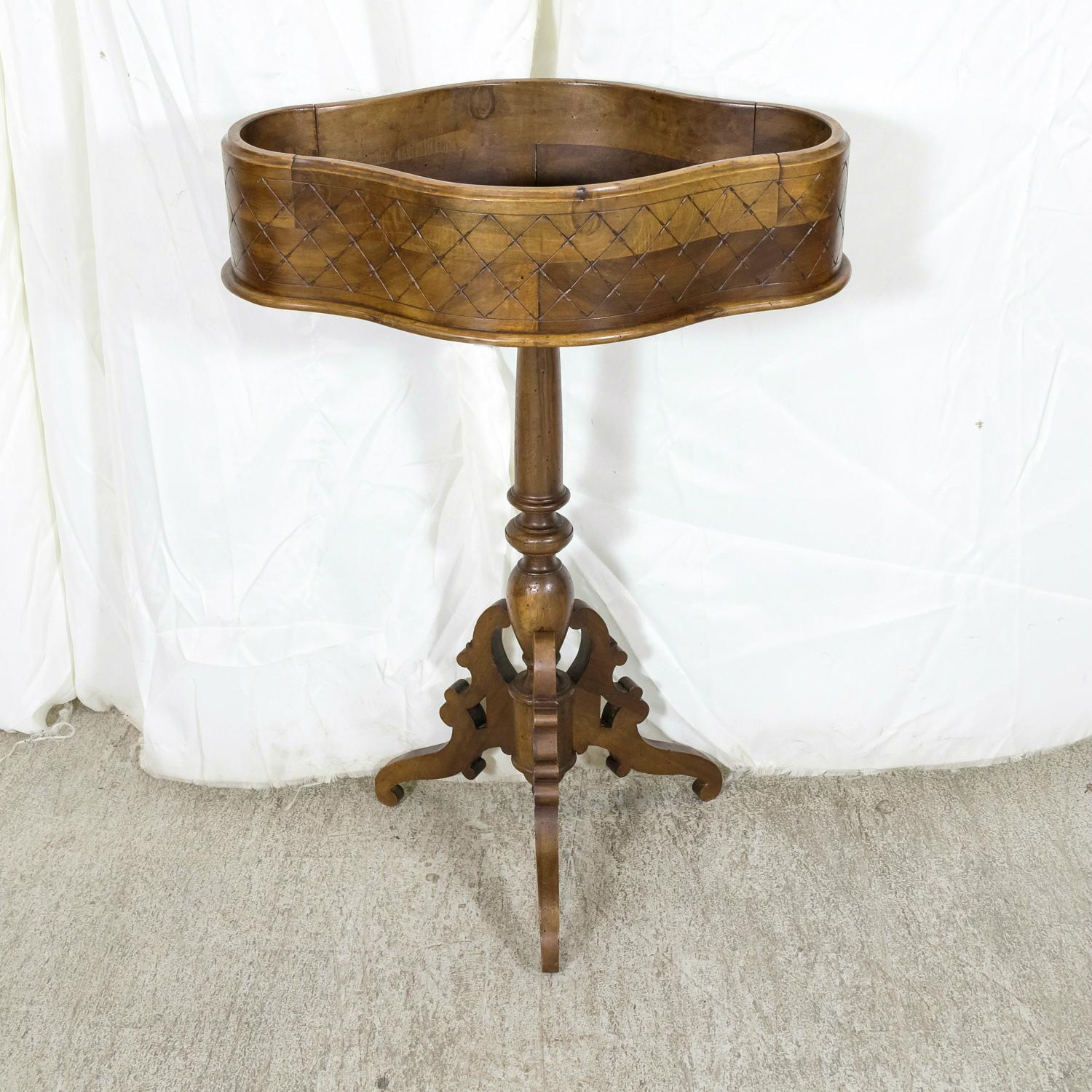 A beautiful 19th century French oval shaped and carved walnut jardinière or planter raised on a turned and carved baluster with a tripod base, circa 1870s. Carved on all sides with a cross hatch pattern, making it perfect to float in a