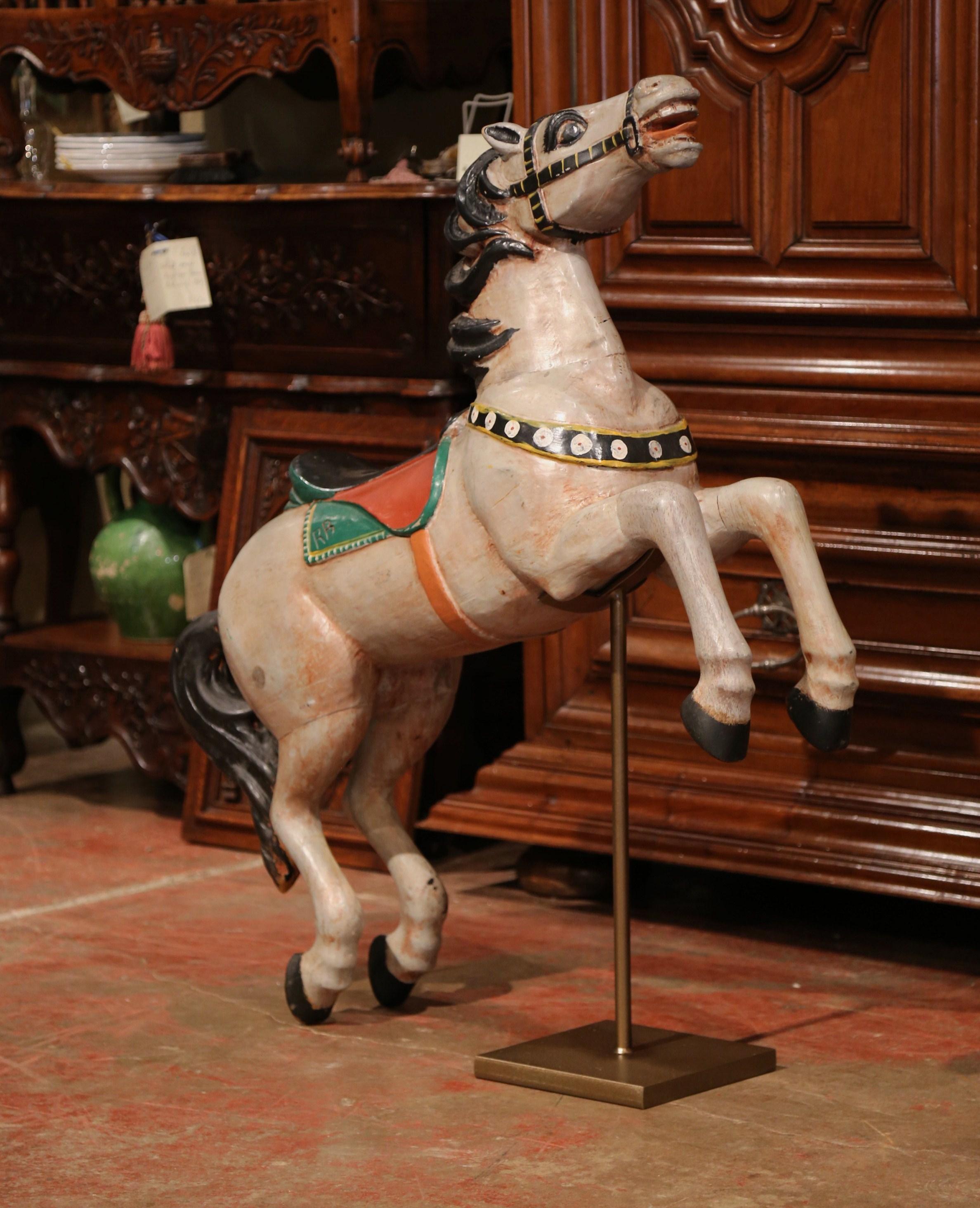 Decorate a playroom or a game room with this antique wooden carousel horse sculpture. Carved in France circa 1870, the charming pine animal is hand painted in a grey, green, red and black palette and rests on a newly painted iron bracket with nice
