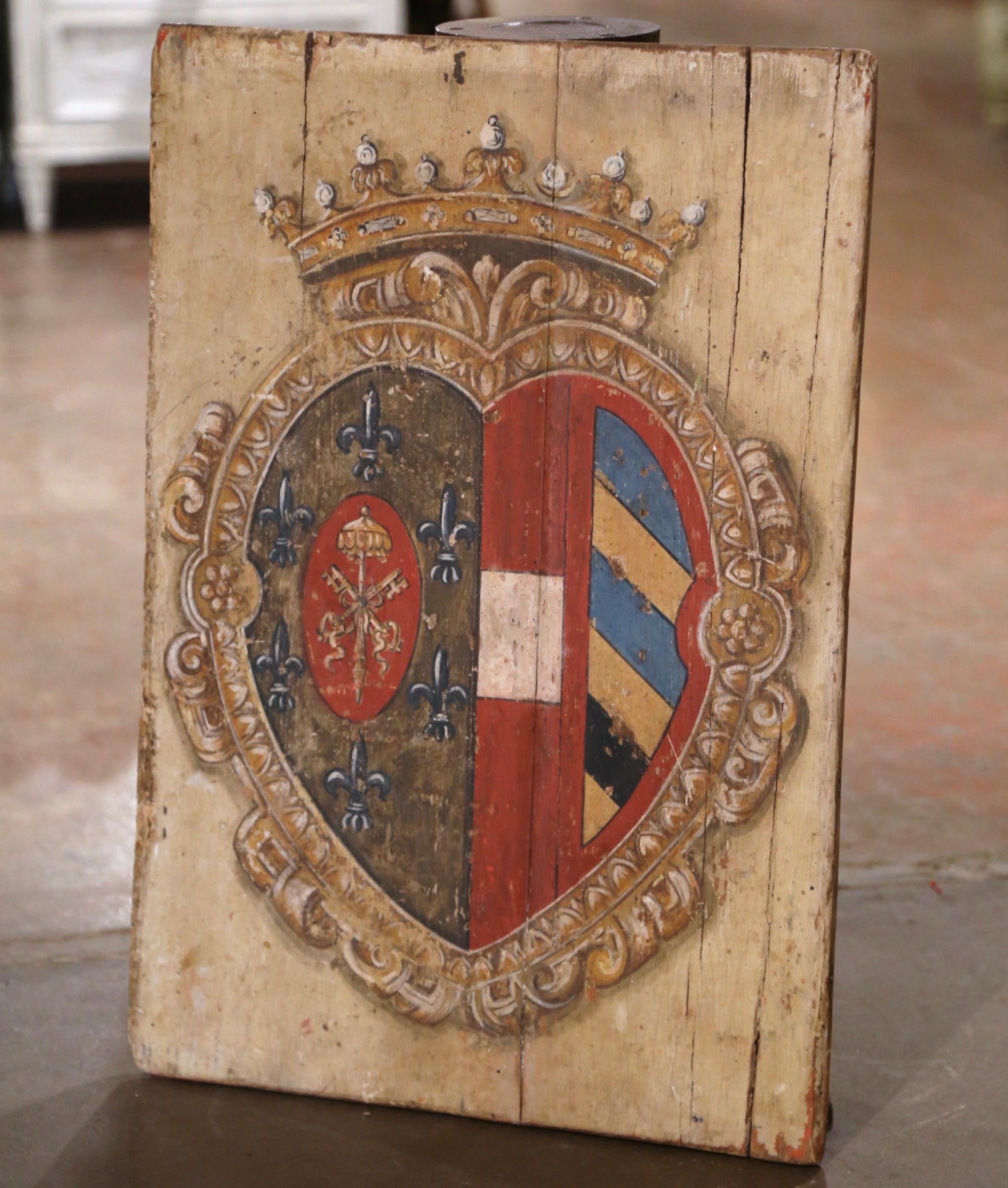 Embellish your wall with this colorful antique shield to bring rustic, old-world charm to a den, office or game room. Hand-carved in France, circa 1870, the crest features a hand painted central coat of arms shaped as a heart, and decorated with