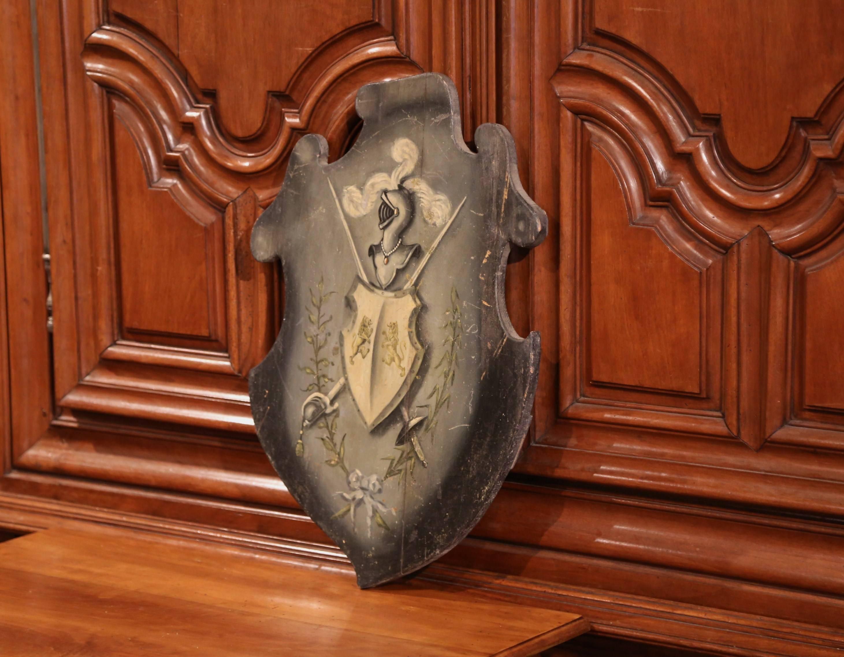 Embellish your study or library with this elegant, antique coat of arms. Carved in France, circa 1870, the traditional, hand painted crest features a central shield decorated with lions, swords and foliage. The top of the shield has a helmet from a