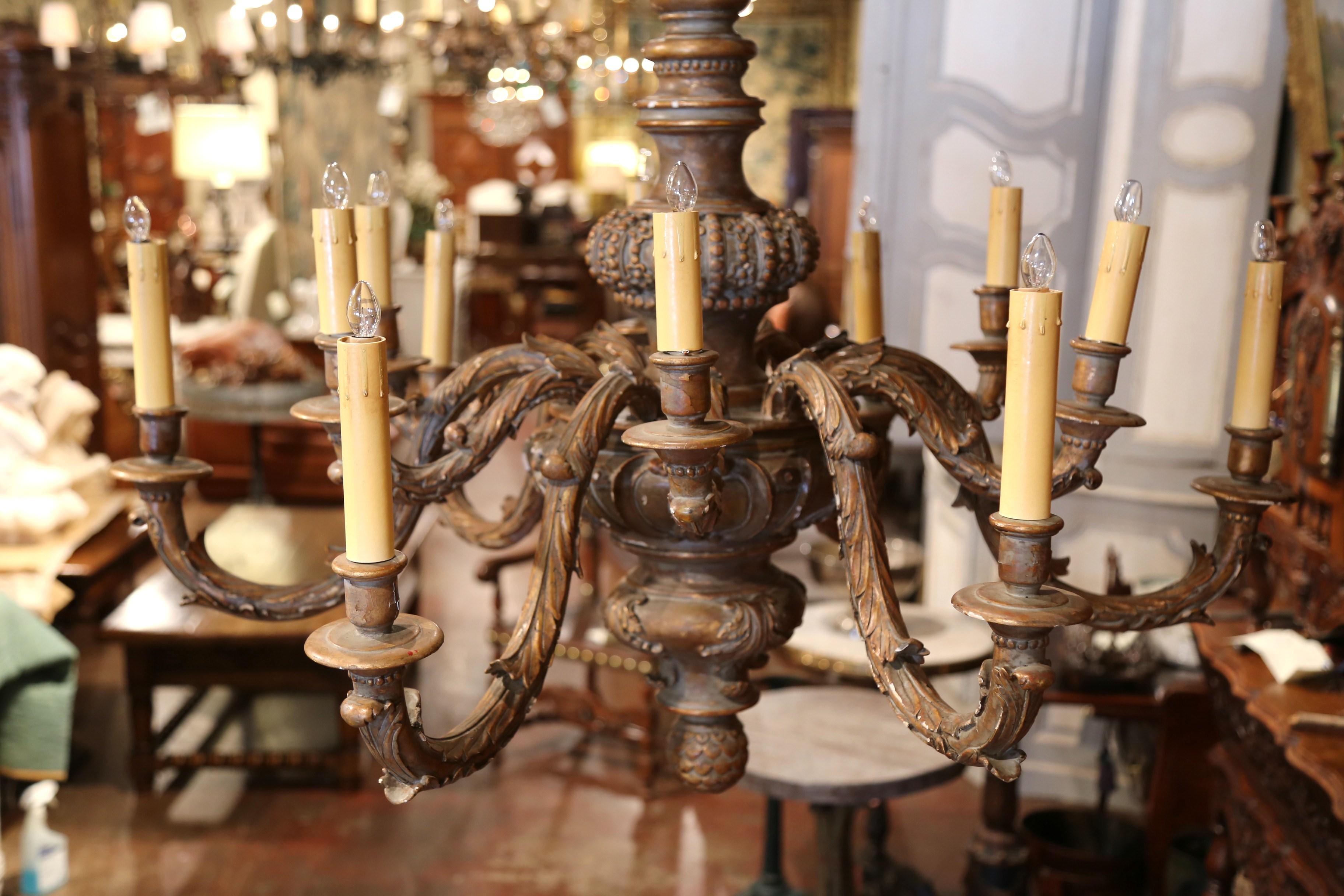 Decorate a dining room or a den with this large antique wooden chandelier. Crafted in France circa 1880, the light fixture is round in shape and features two row of arms of different lengths around the thick turned central stem; each carved and
