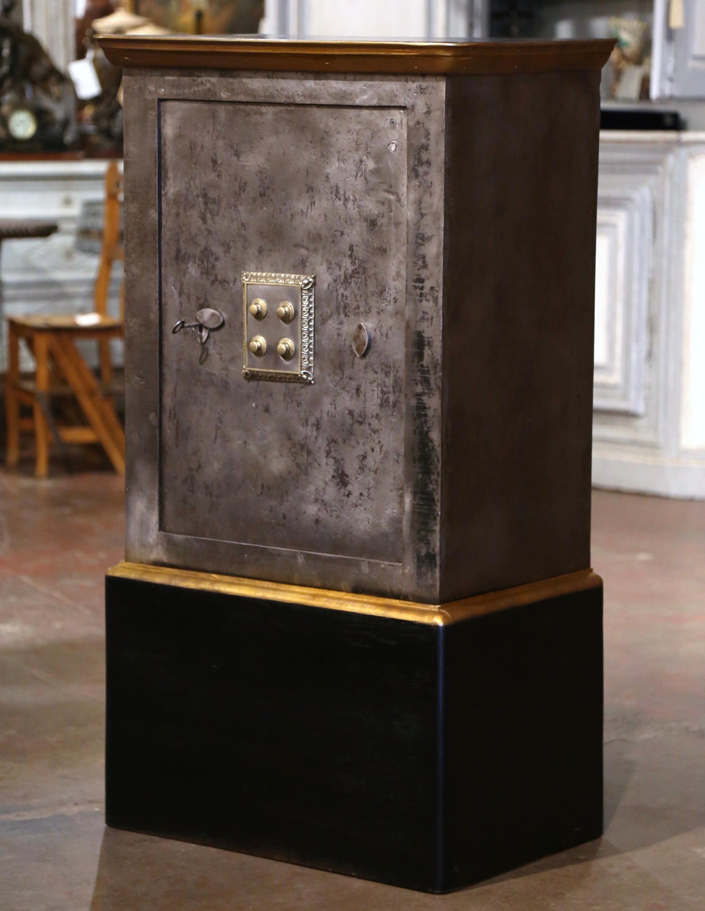 This antique wooden and iron safe, was crafted in Paris, France, circa 1870. The black painted and polished iron safe stands on a separate carved oak base decorated with a straight bottom plinth. The safe is topped with a removable oak surface. The