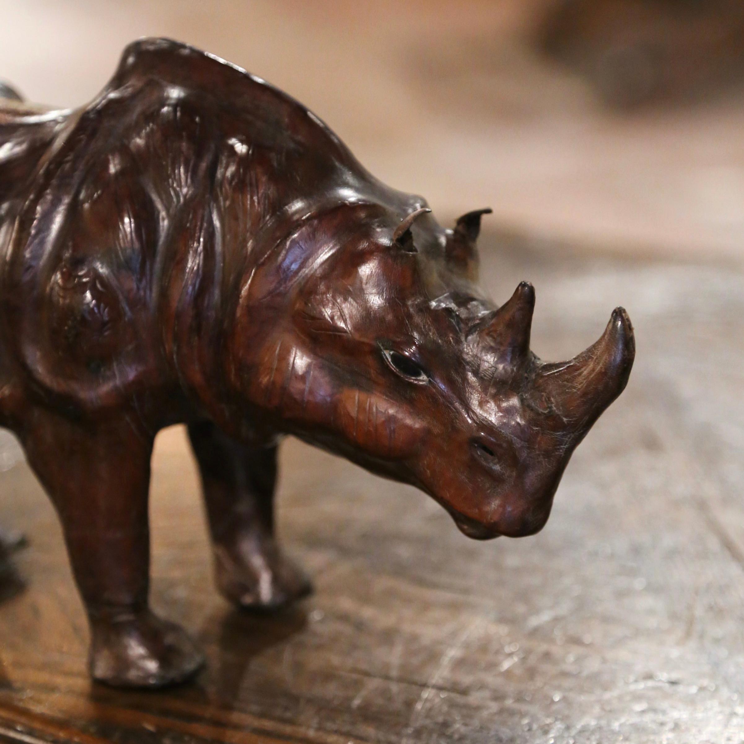 This beautiful, antique rhinoceros sculpture was crafted in France, circa 1880. The detailed leather figure standing on his four legs is in excellent condition and adorns a rich old patinated finish. Place this sculpture on a shelf in a study or
