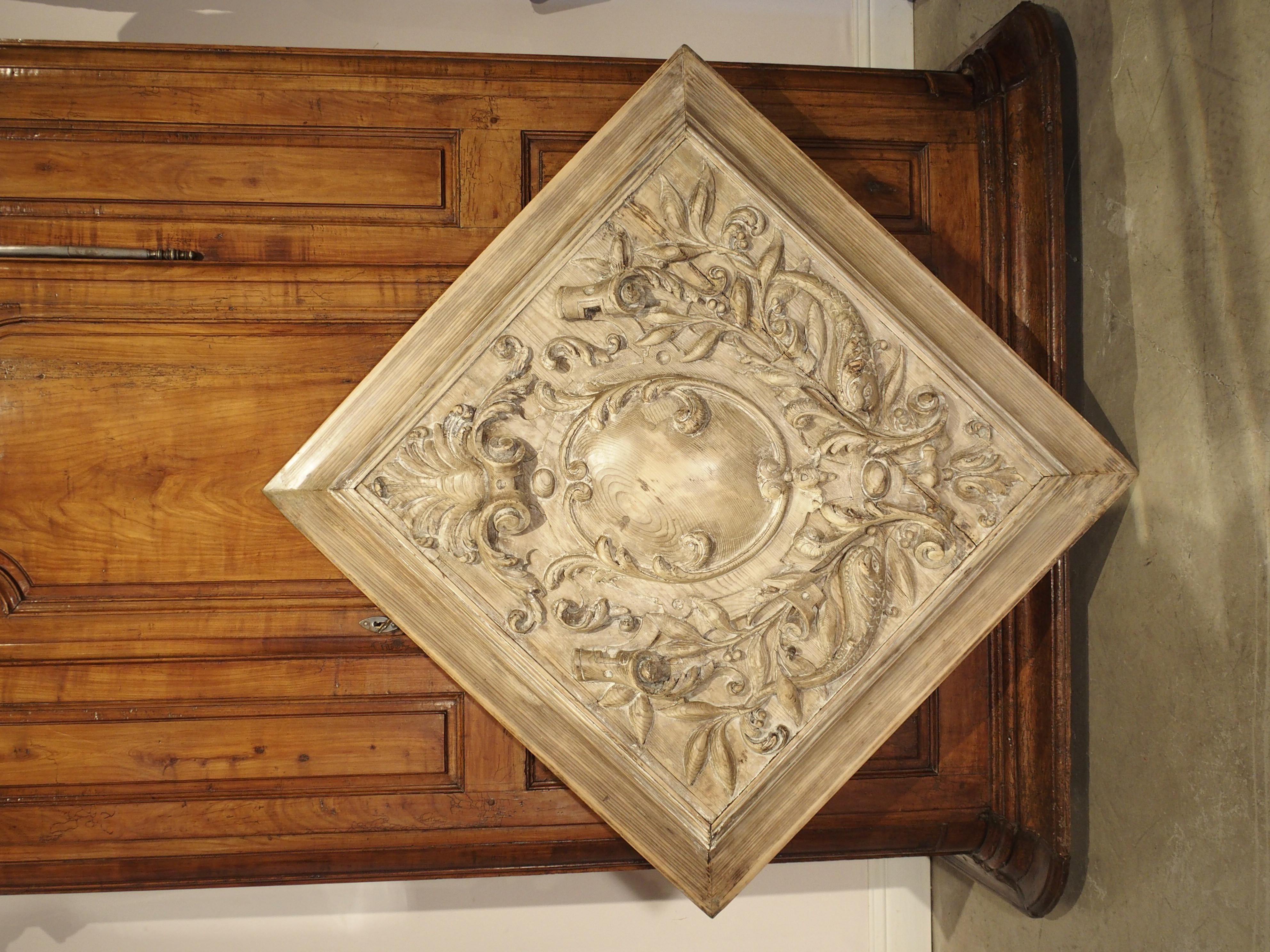This important antique pine plaque would make an elegant addition over a mantel or stone fireplace. Square in shape and hand carved in France, circa 1860, the large panel features a shell motif at the pediment with a central crest flanked by a pair