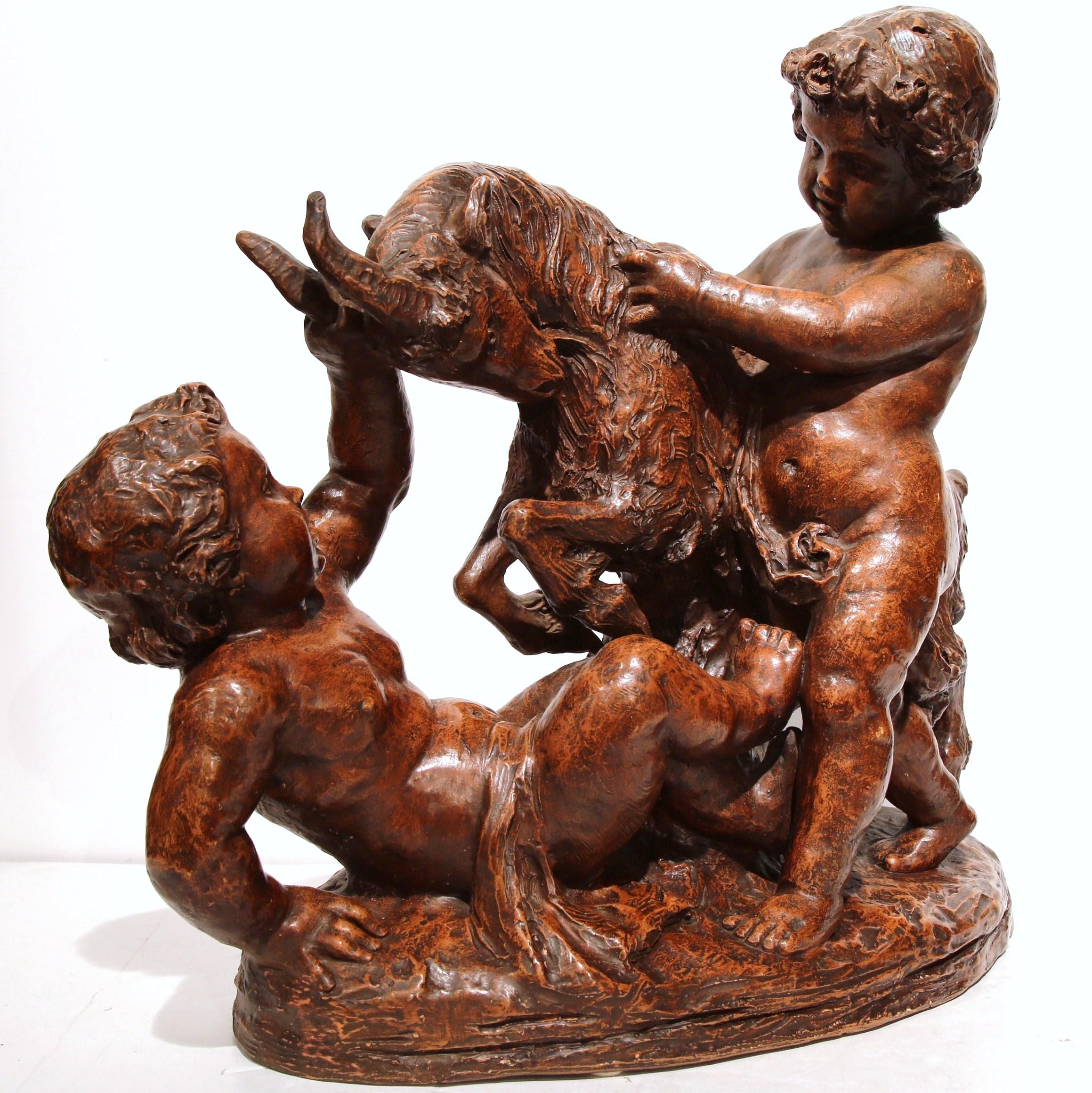 This large, charming, antique clay cherub composition was sculpted in France, circa 1880. The sculpture depicts two angelic children playing with a goat; the cherubs are nicely carved with detailed facial expressions and movement. The art work is