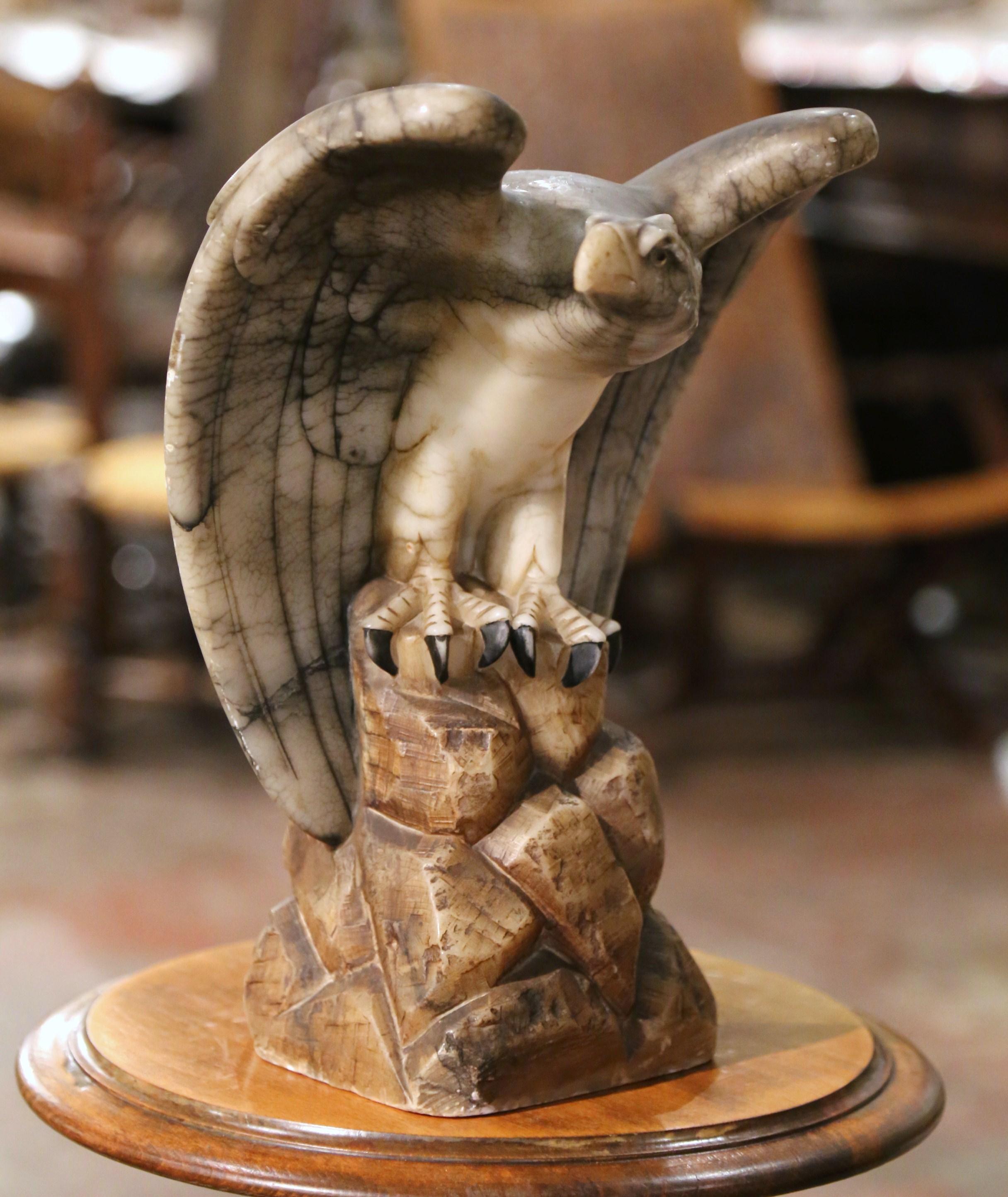 Decorate a shelf or a man's office desk with this stately antique marble eagle. Created in France circa 1880, and carved of variegated marble, the tall sculpture depicts a proud bird standing on integral square rocky-form base, with head turned, and