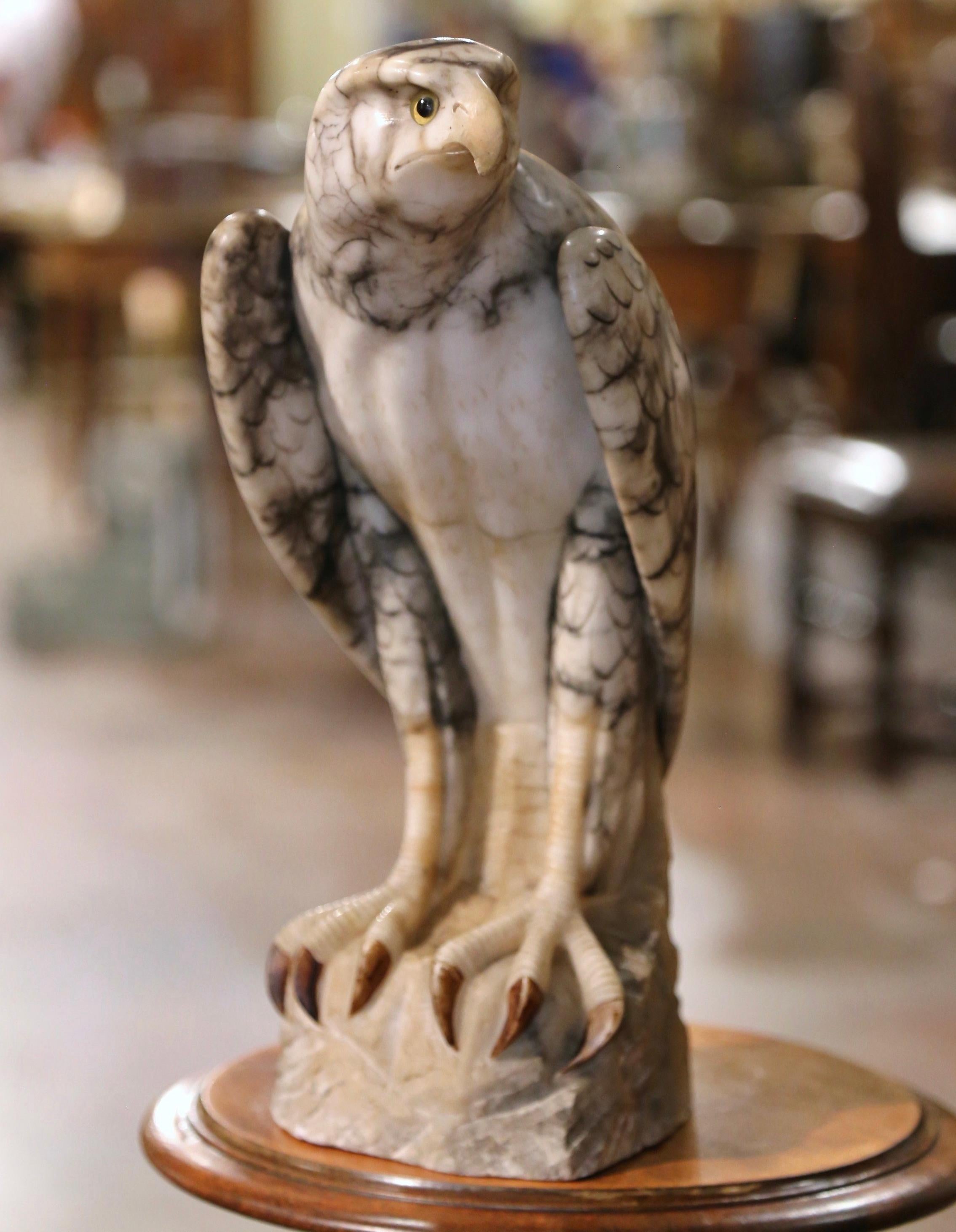 Decorate a shelf or a man's office desk with this stately antique marble eagle. Created in France circa 1880, and carved of variegated marble, the tall sculpture depicts a proud bird standing on integral square rocky-form base with his head turned.