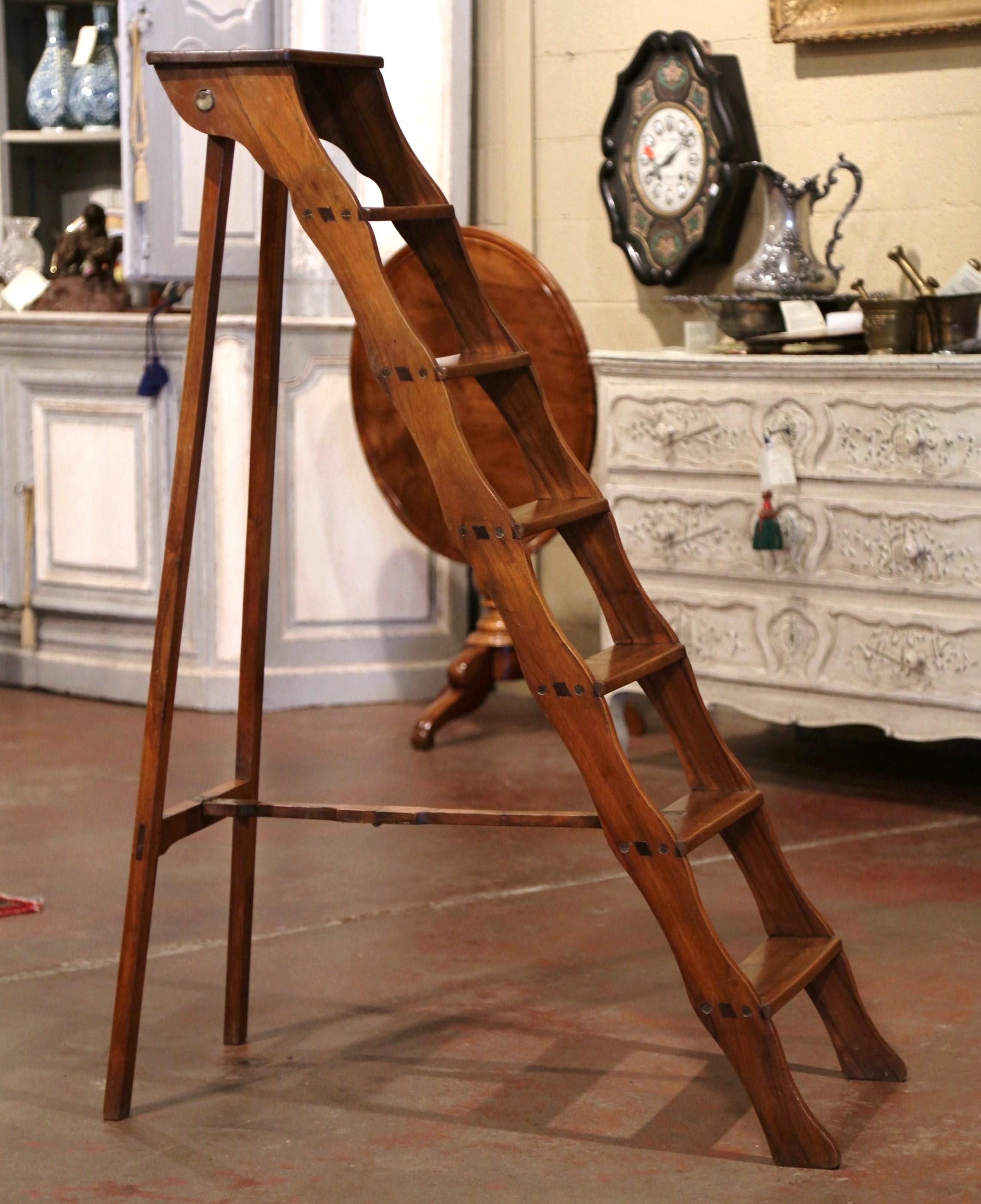 Decorate a study or a library with this whimsical antique ladder. Crafted in Lyon, France circa 1880 and made of walnut, the scalloped stairs features six graduated steps to one side and connected to the opposing support with a wooden and iron