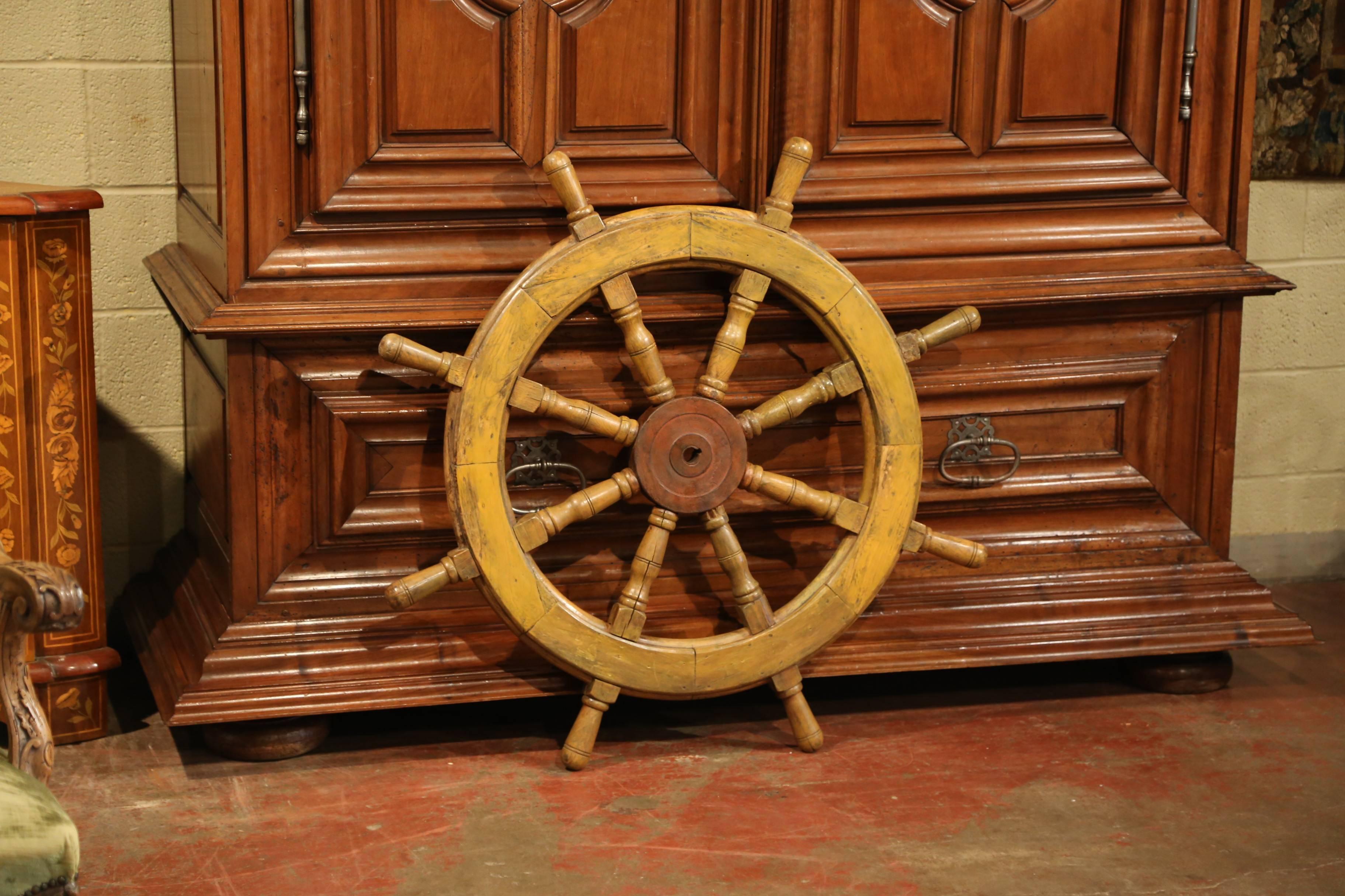 This large antique wooden ship wheel was carved in France, circa 1880. The traditional, fruitwood nautical object has its original metal brace around eight turned spindles with handles. The traditional marine accessory is in excellent condition with