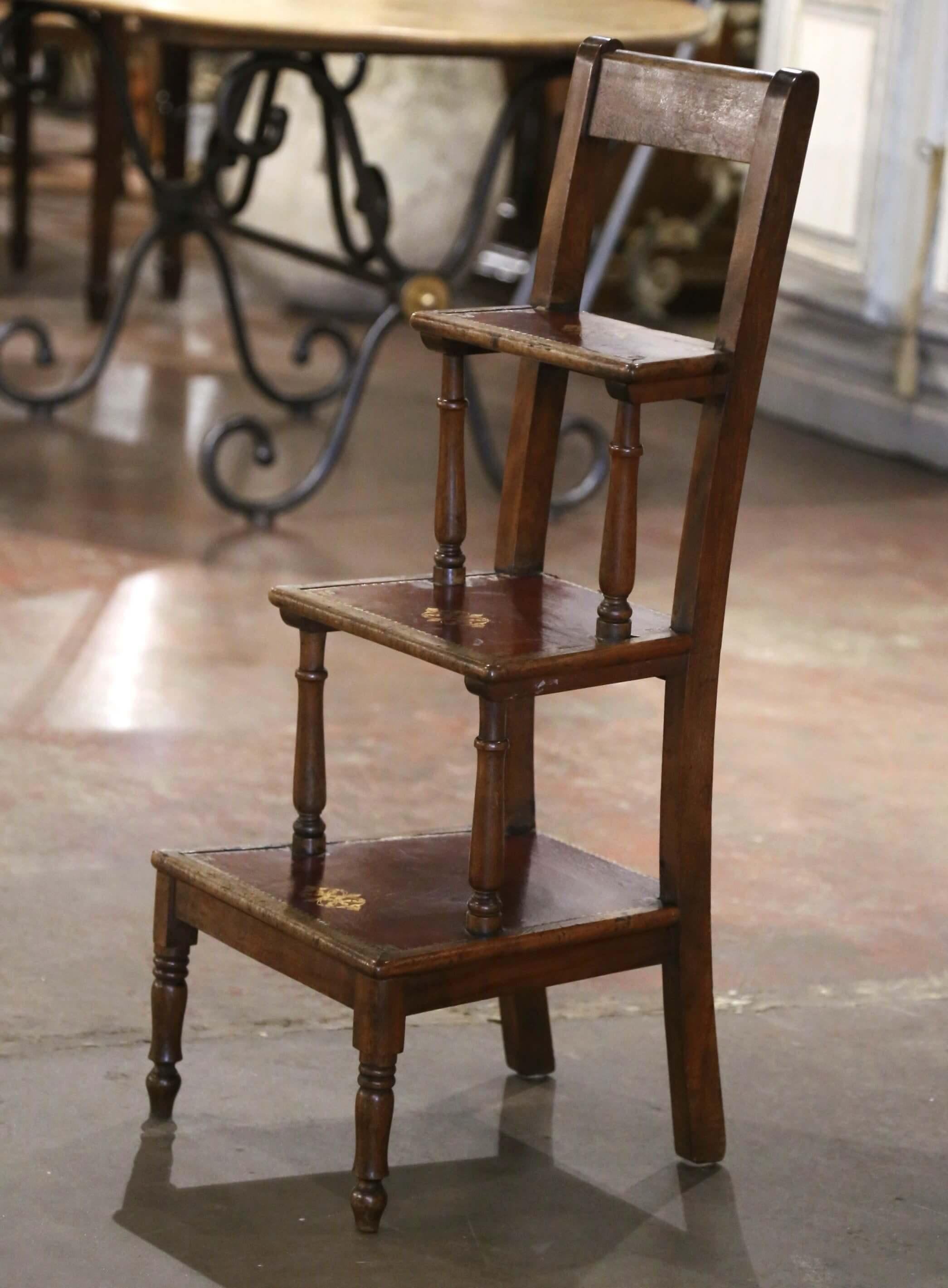 Questa scala da biblioteca antica è stata creata in Francia, intorno al 1880. La scala a tre gradini, con maniglia di sostegno sullo schienale, poggia su piccole gambe anteriori tornite. Ogni gradino è rivestito da un inserto in pelle bordeaux