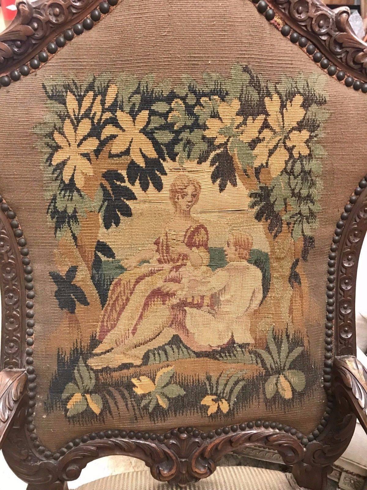Finely carved antique French Renaissance walnut open armchair with a shaped crest rail draped with acanthus leaves. The back with needlepoint tapestry fabric depicting a garden scene with paramours.

The beautifully contoured arms with scrolled
