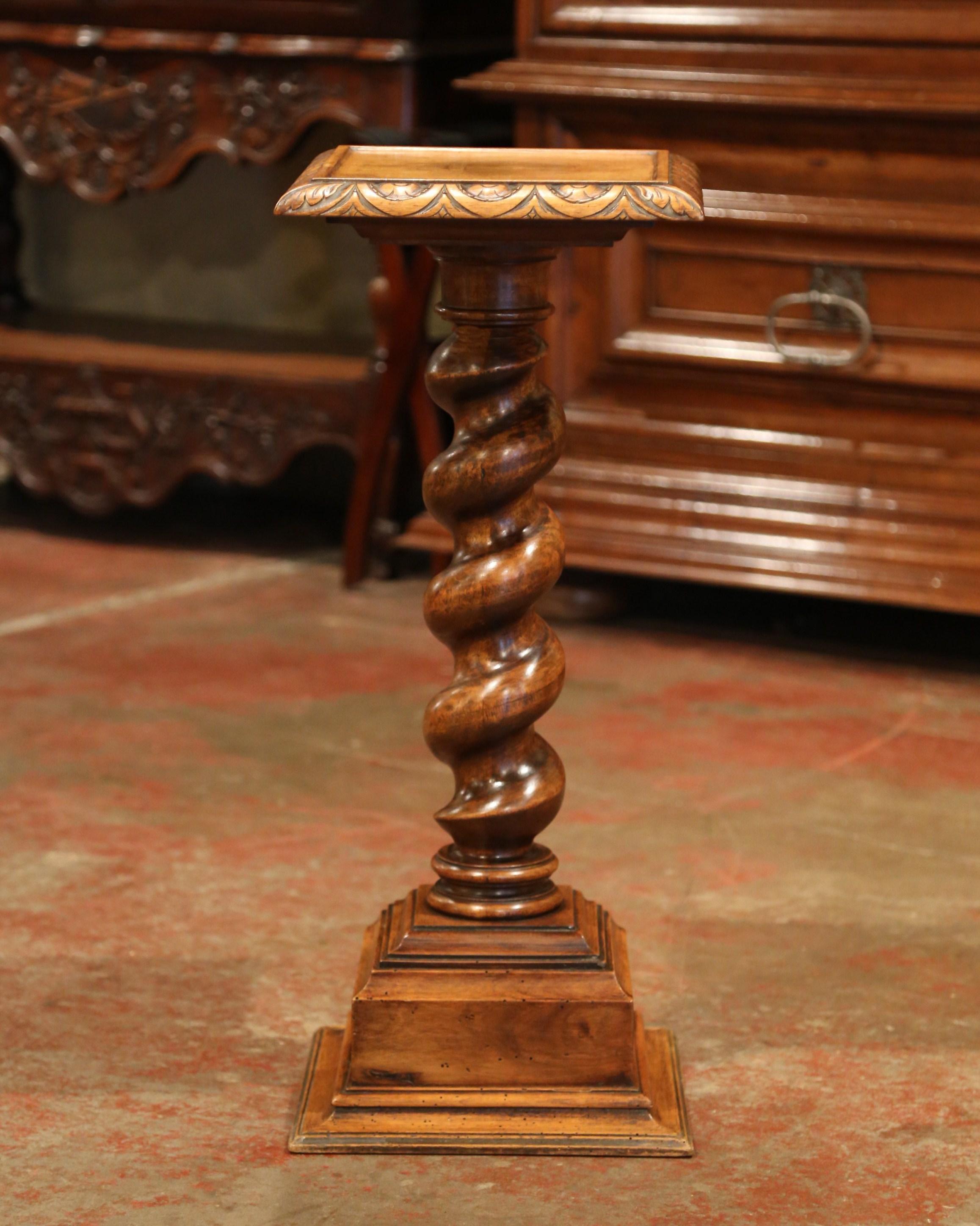 Display a bust or a flower vase on this elegant, antique fruit wood pedestal. Crafted in Southern France circa 1870, the versatile column sits on a thick decorative square plinth. The walnut pedestal has a hand carved barley twist stem, which is