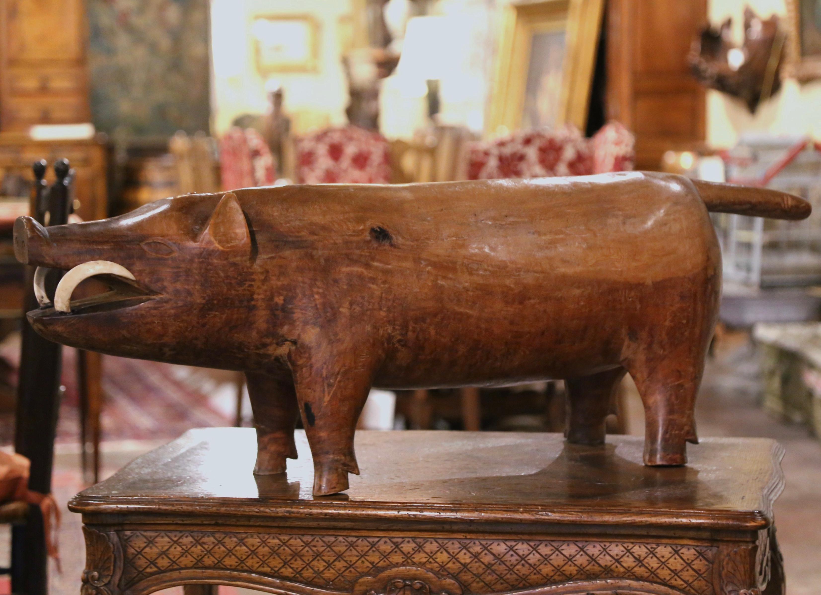Rest your feet on this interesting footstool! crafted in France, circa 1890 and built in one piece of walnut, the hand-carved sculpture depicts a boar figure sniffing; the hog faces forward with mouth open showing real tusks, and tail sticking out