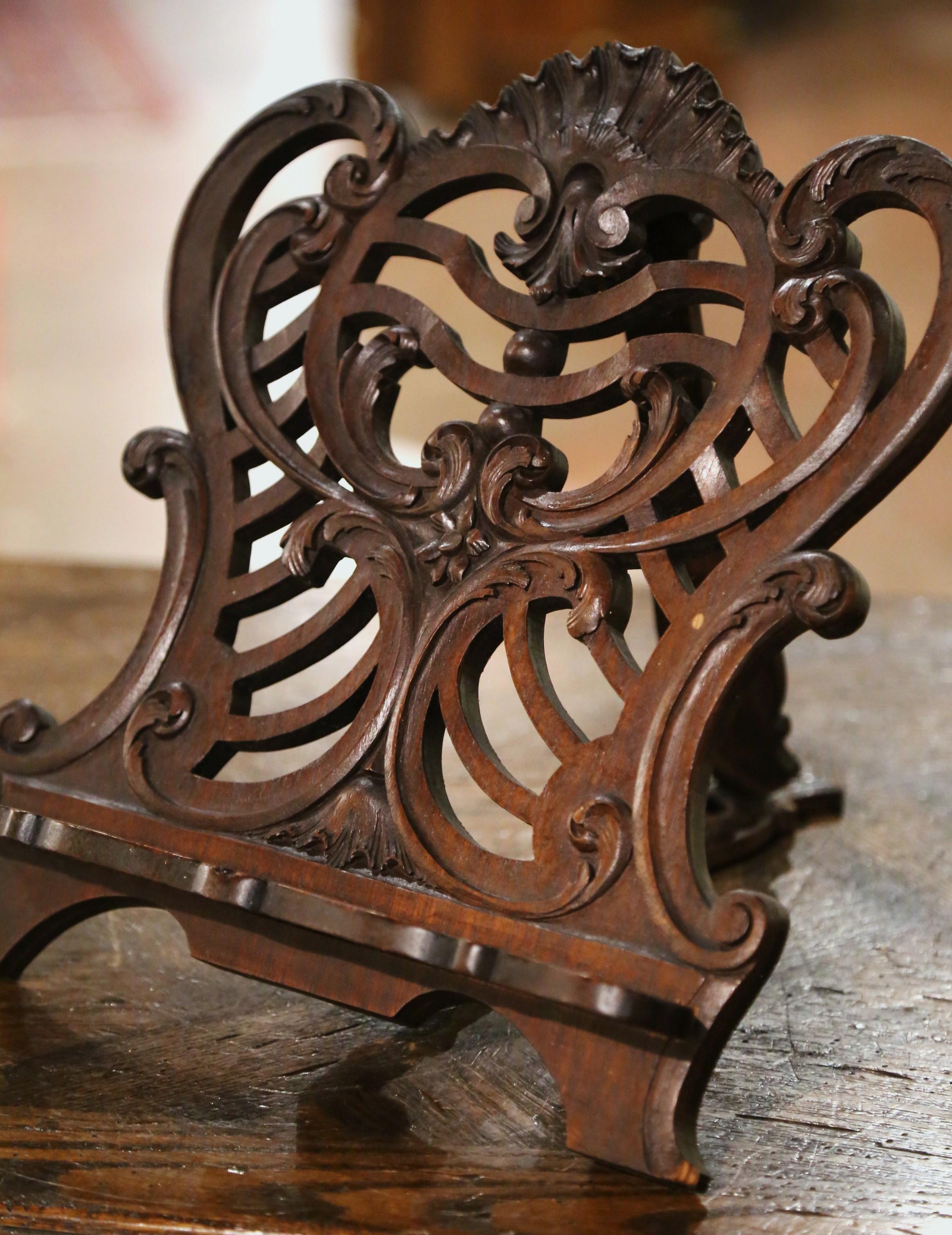 Place a cookbook on this antique stand for easy meal prep in the kitchen! Created in France, circa 1890, and built of walnut, the Classic table book stand is decorated with hand carved and pierced scroll motifs including a larger shell in the