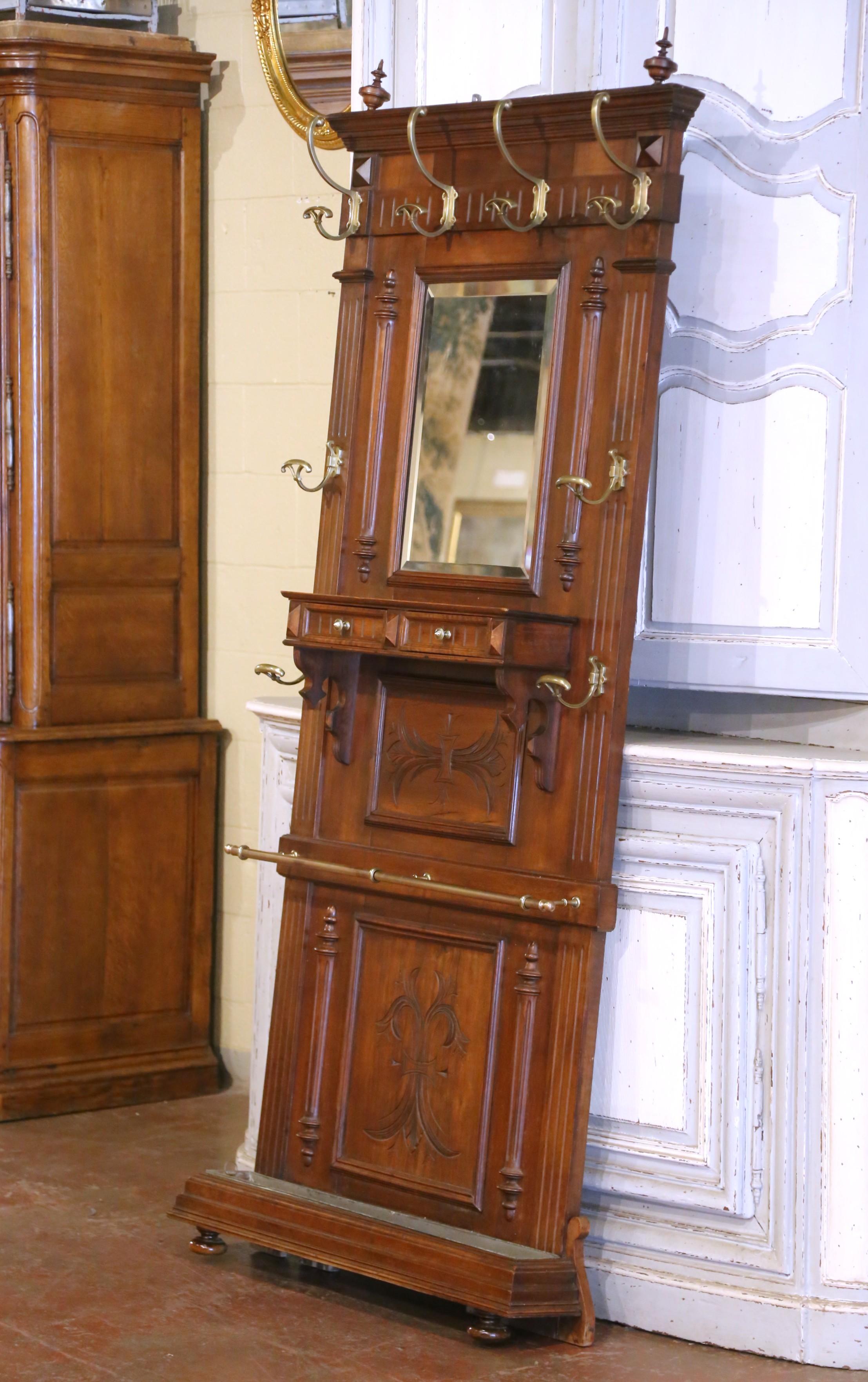 Add classical elegance and practical charm to an entryway or mudroom with this richly carved antique hall tree. Crafted in France circa 1880, the tall and stately piece is built from solid walnut with warm tones and a deep patina. The architectural