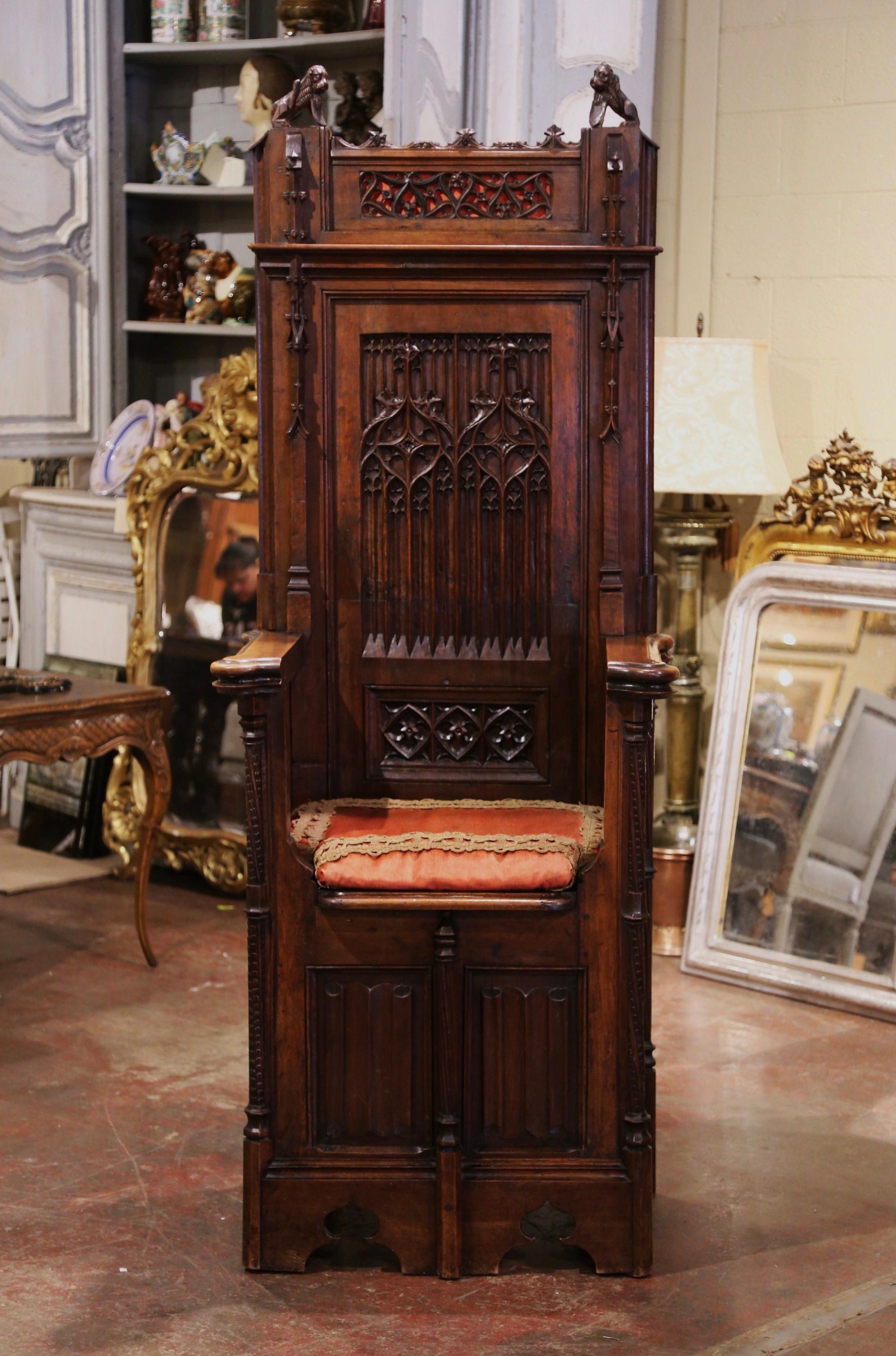 This Gothic “Cathedre” (French for Cathedra or bishop’s throne) was crafted in southern France circa 1860. Built of walnut, the chair stands on bracket feet over a scalloped plinth apron. The tall back is hand carved with pointed arch and tracery