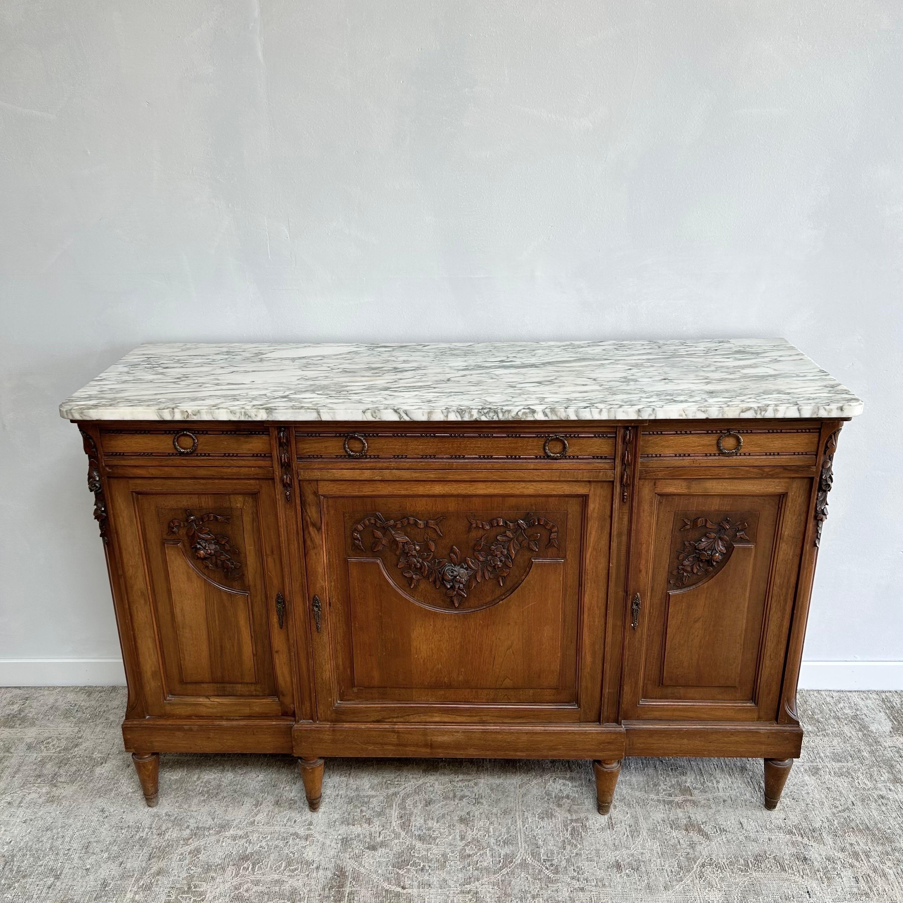 Beautiful Walnut Buffet with carved rose swags, and white marble top with gray veins. 
Working 3 drawer, 3 door buffet is solid and sturdy ready for everyday use.
No keys are included or needed. The marble top is not attached, it does come apart