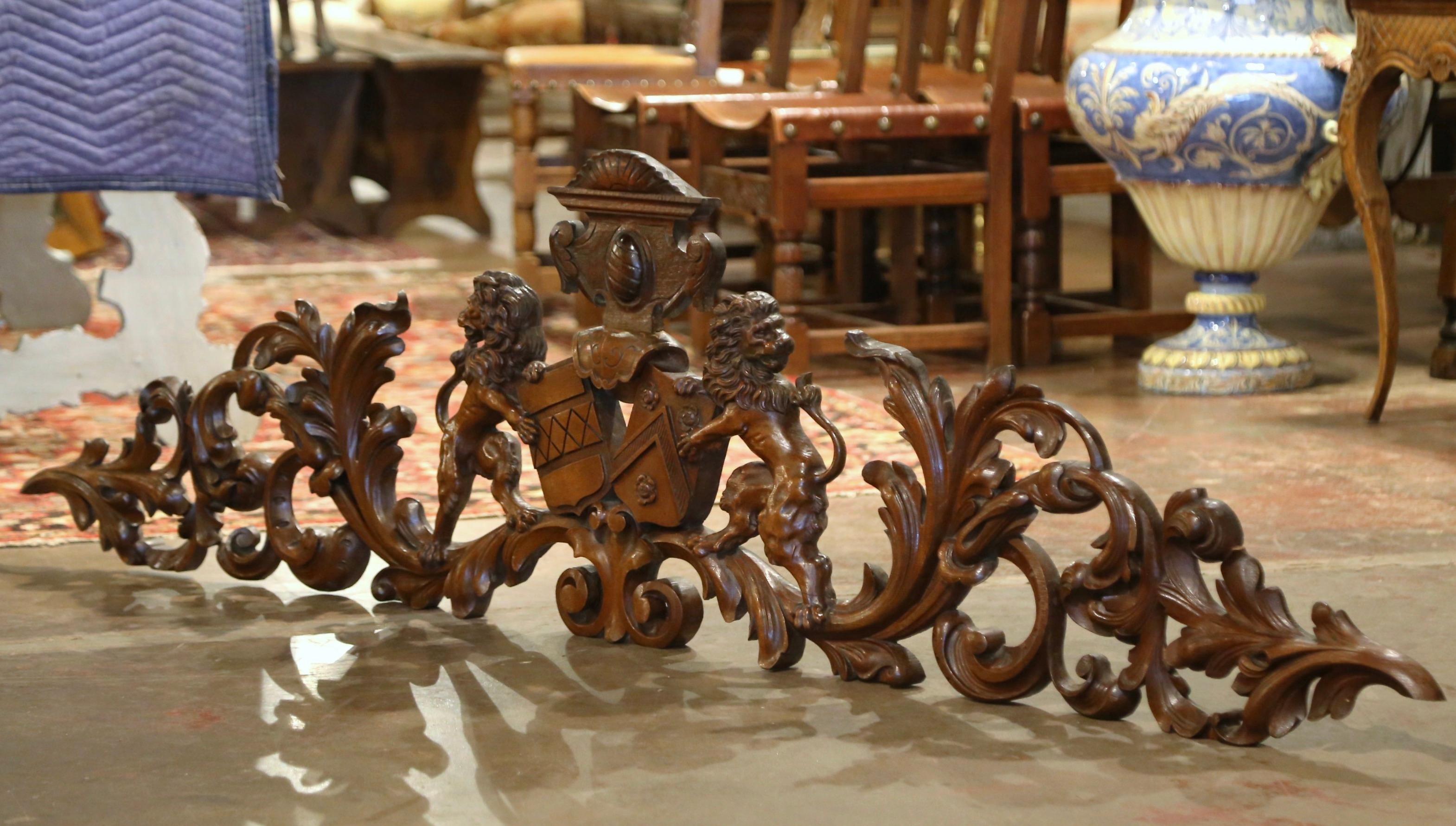  Crafted in France circa 1860 and built of solid walnut, the large wall hanging sculpture features heavily carved motifs throughout including hand carved lion figures holding a family crest on both sides; it is further embellished with acanthus