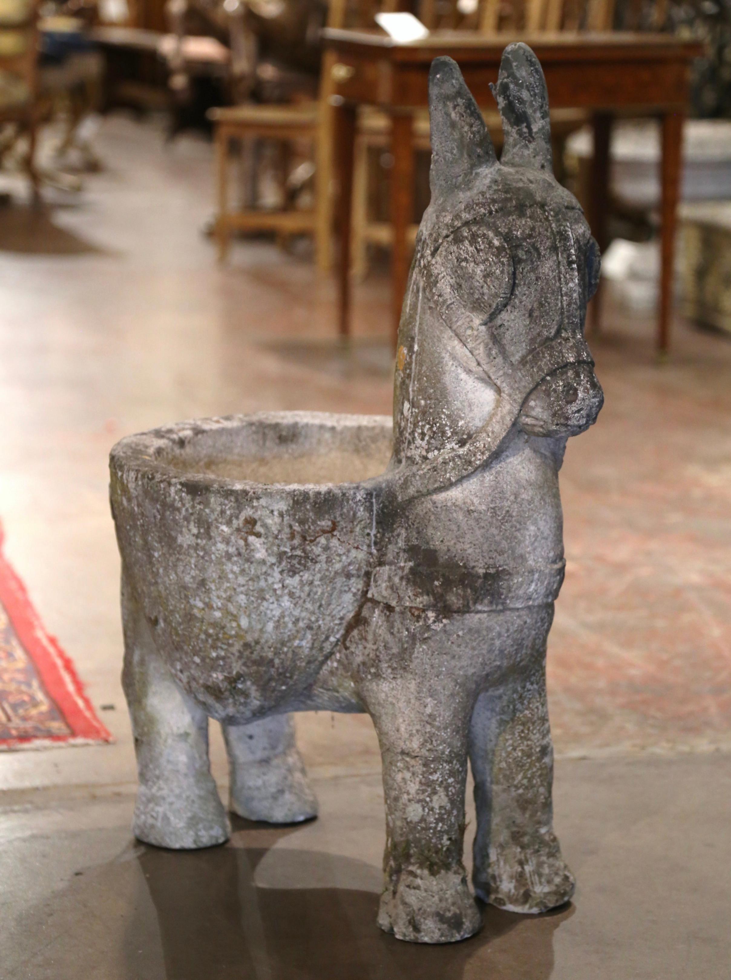 Decorate a patio or backyard with this antique stone donkey planter. Crafted in France circa 1870 and carved of concrete, the sculpture features a standing donkey-form sculpture with a large belly-like flower holder. The tall and heavy cheerful