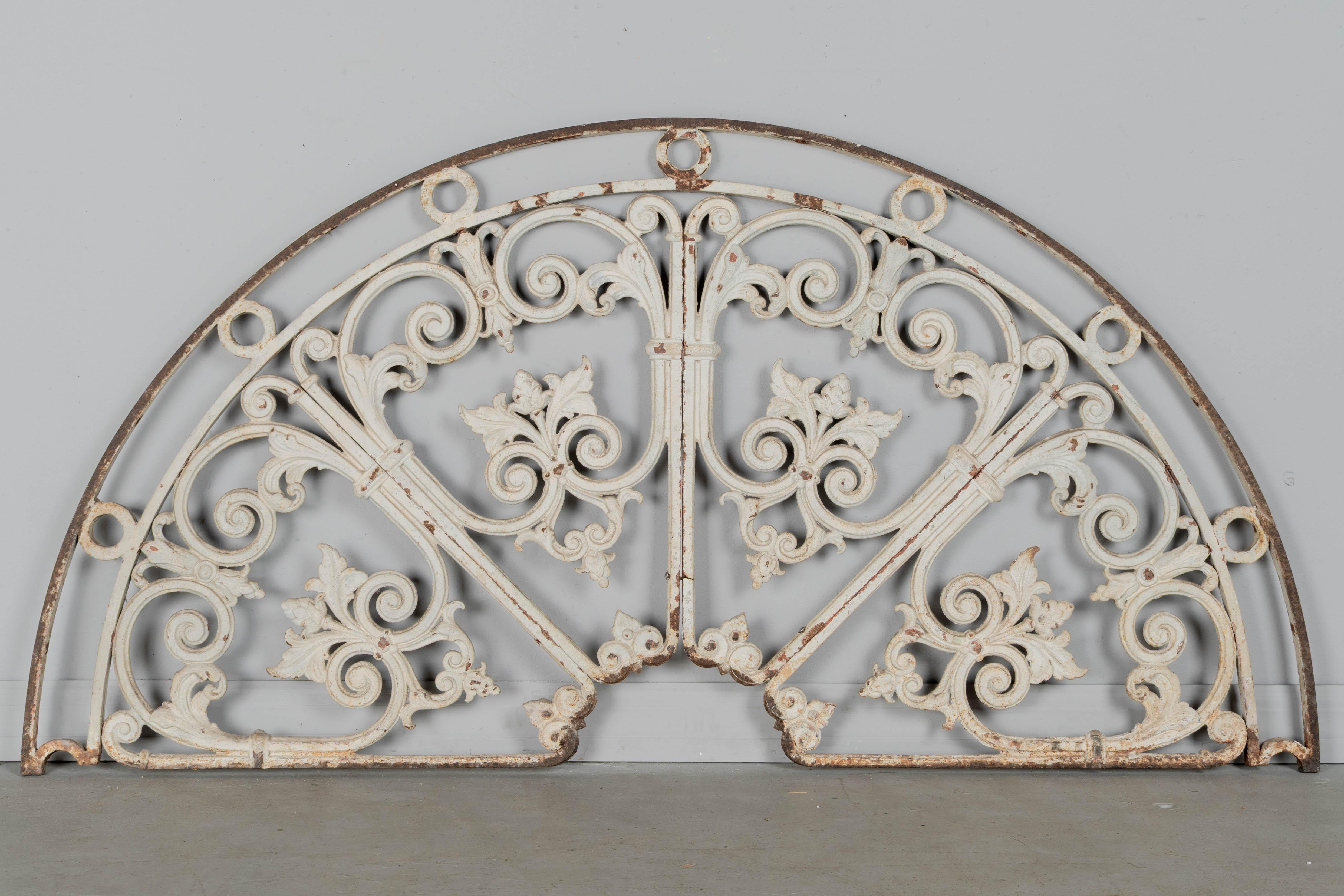 A 19th century French salvaged architectural demilune cast iron grille. White painted patina with some paint loss and rust. Good quality iron work. Perfect for use as decorative wall hanging or garden ornament. Circa 1870-1890.
Dimensions: 53