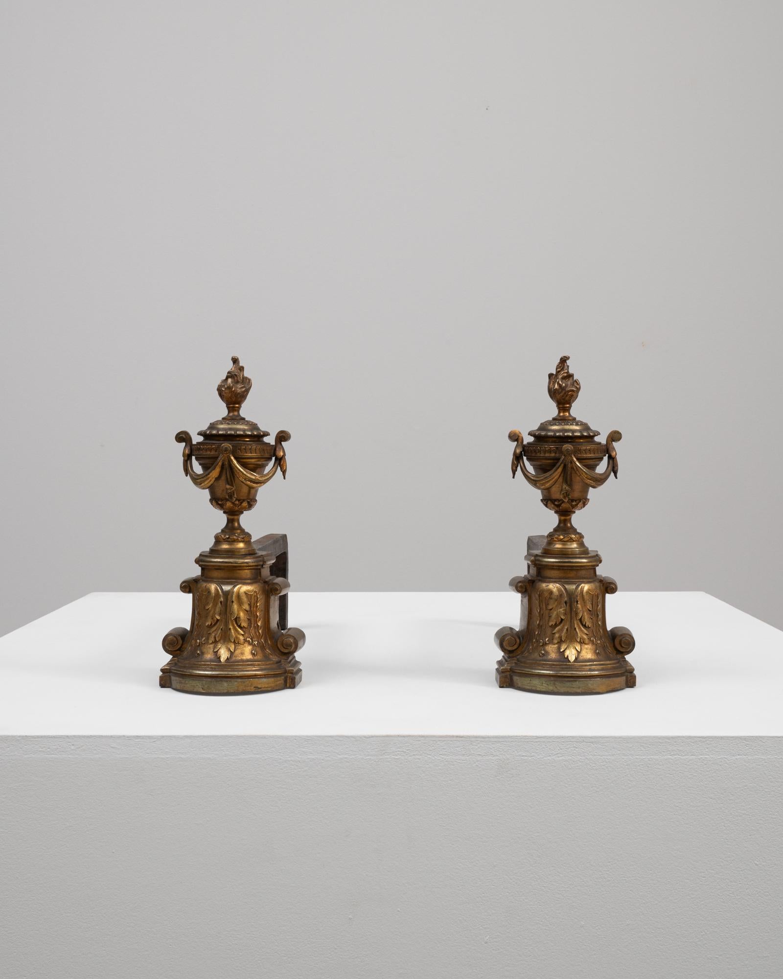 These 19th Century French Cast Iron Fire Dogs boast an ornamental design, rich with the opulent details characteristic of the period. Also known as andirons, these pieces served a functional purpose to support the firewood but also stood as symbols