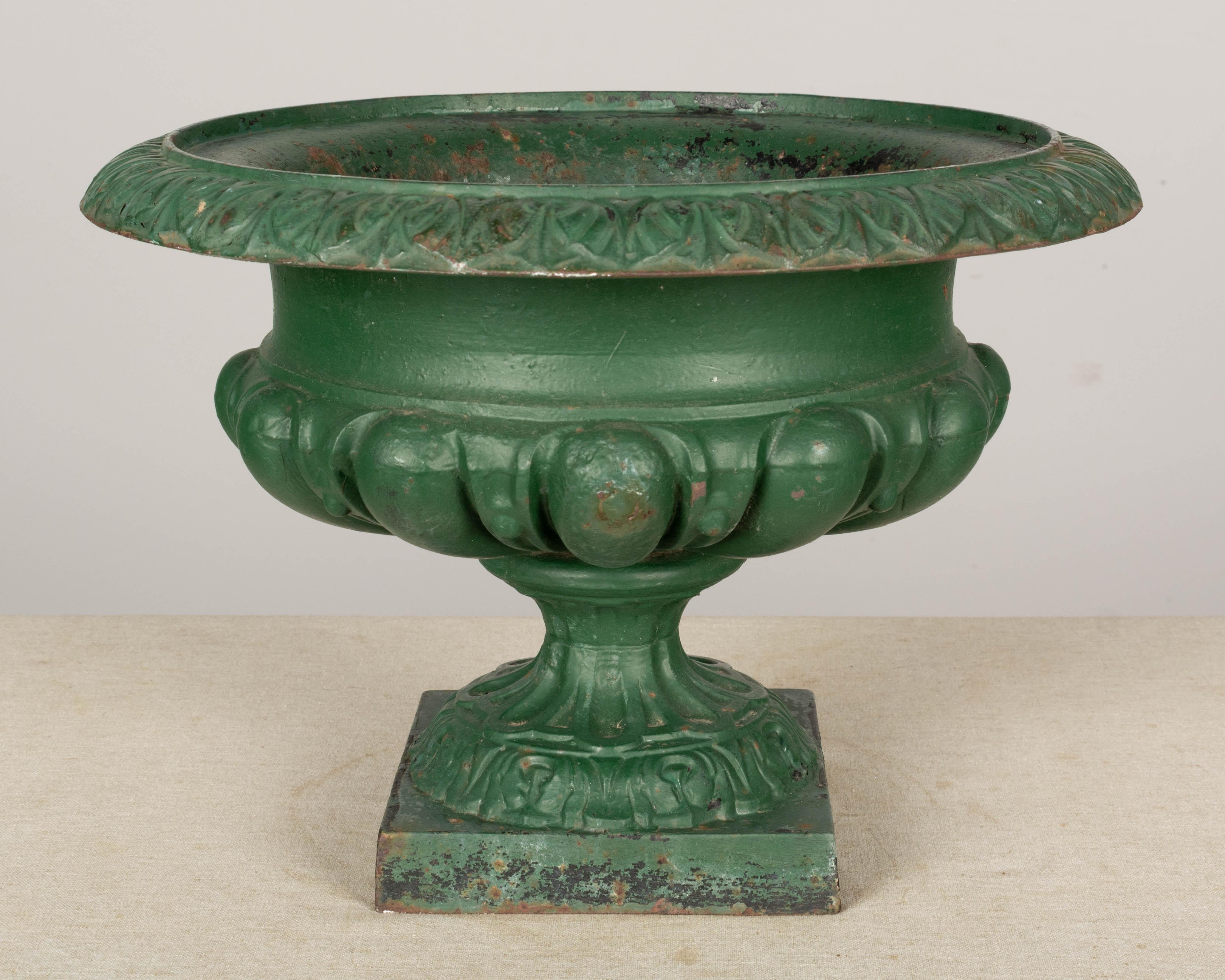 A 19th century French cast iron garden urn planter with pedestal base and green patina. Good condition with minor paint loss and some rust. 
Overall dimensions: 10.5 height x 16