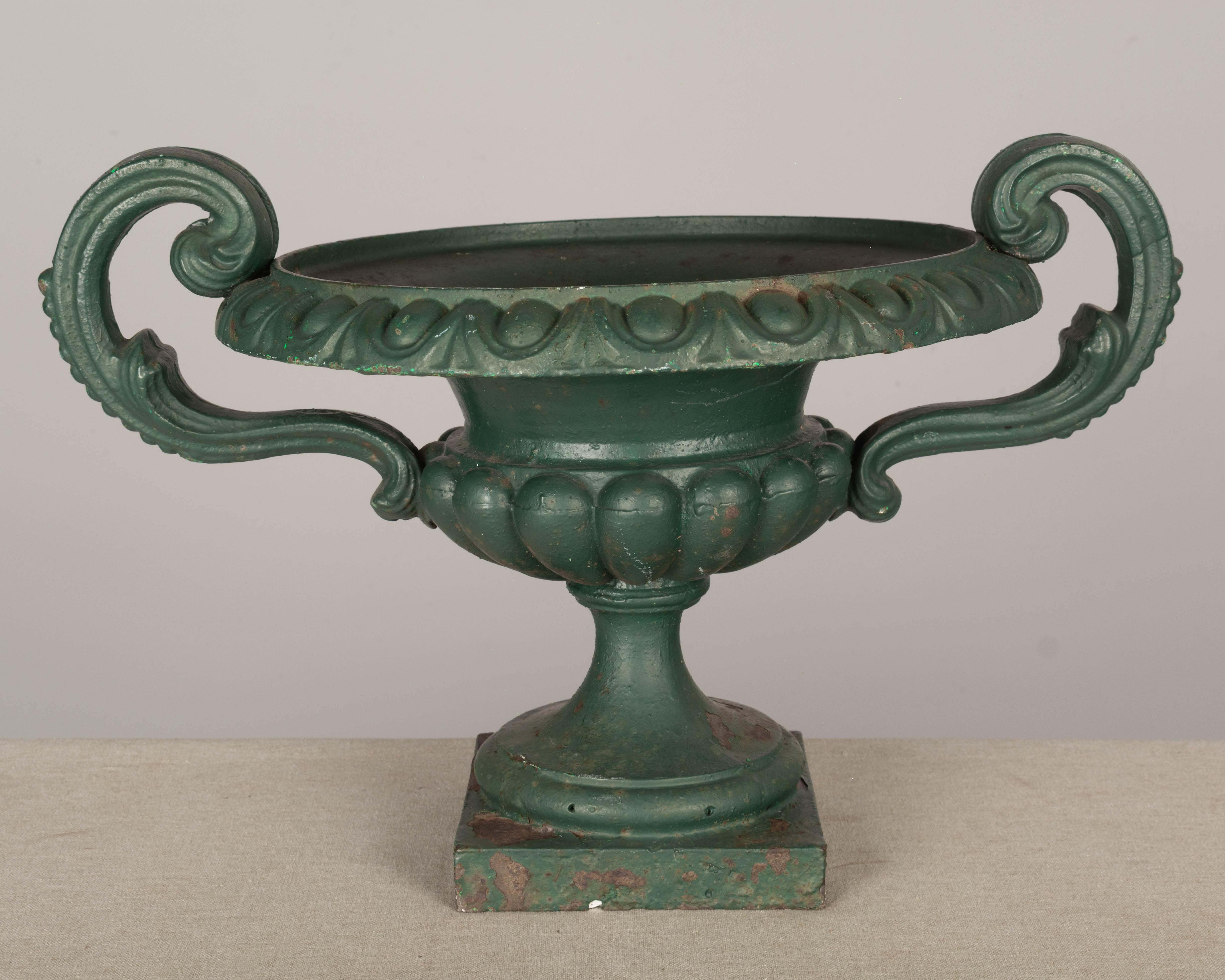 A 19th century French cast iron garden urn planter with handles, pedestal base. Green painted patina with minor losses and some rust. Good condition. Circa 1880-1900. Weight: 25 lbs.
Dimensions: 12
