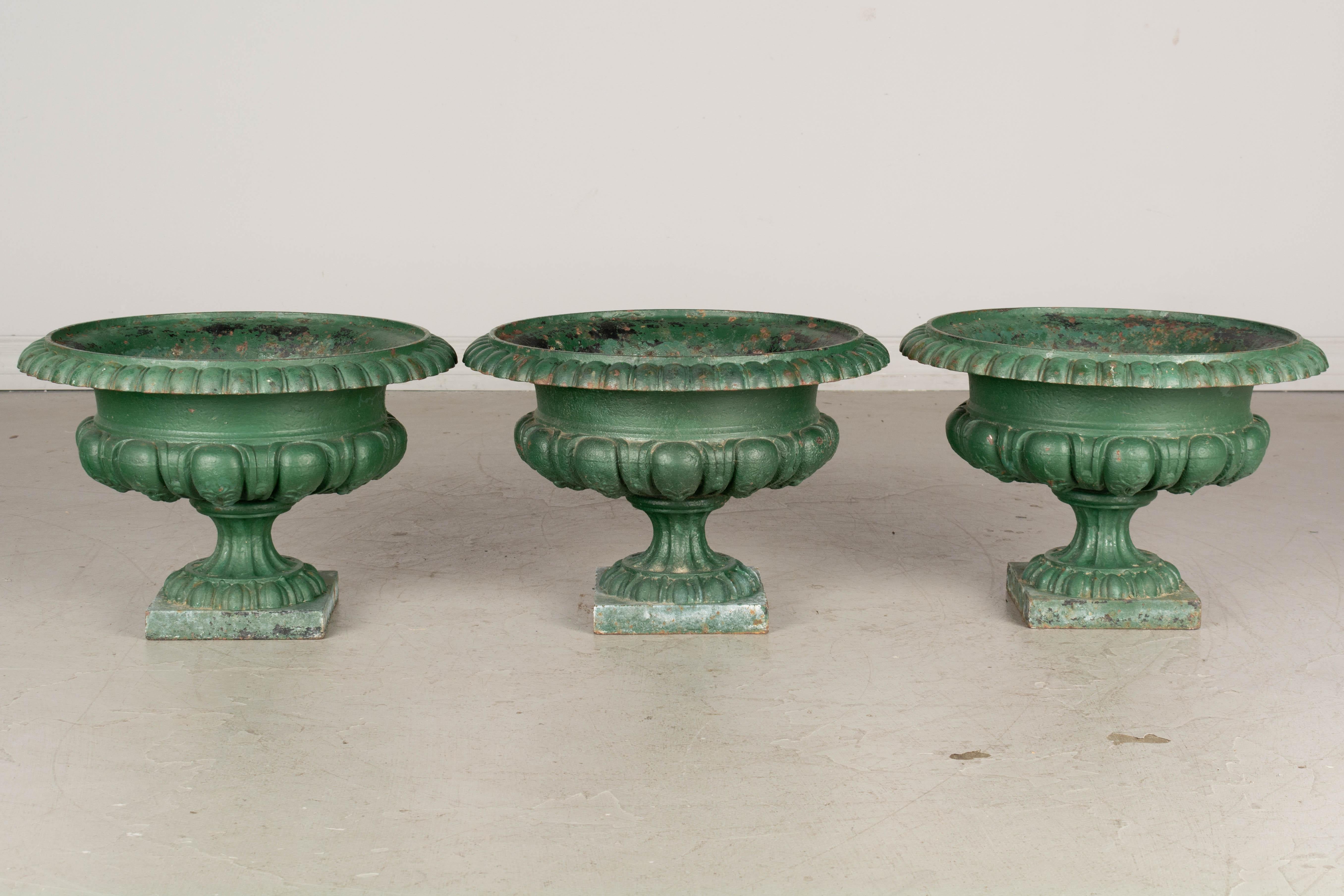 A set of three 19th century French cast iron garden urn planters with pedestal base and green patina. Good condition with minor paint loss and some rust.
Overall dimensions: 10.5 height x 16