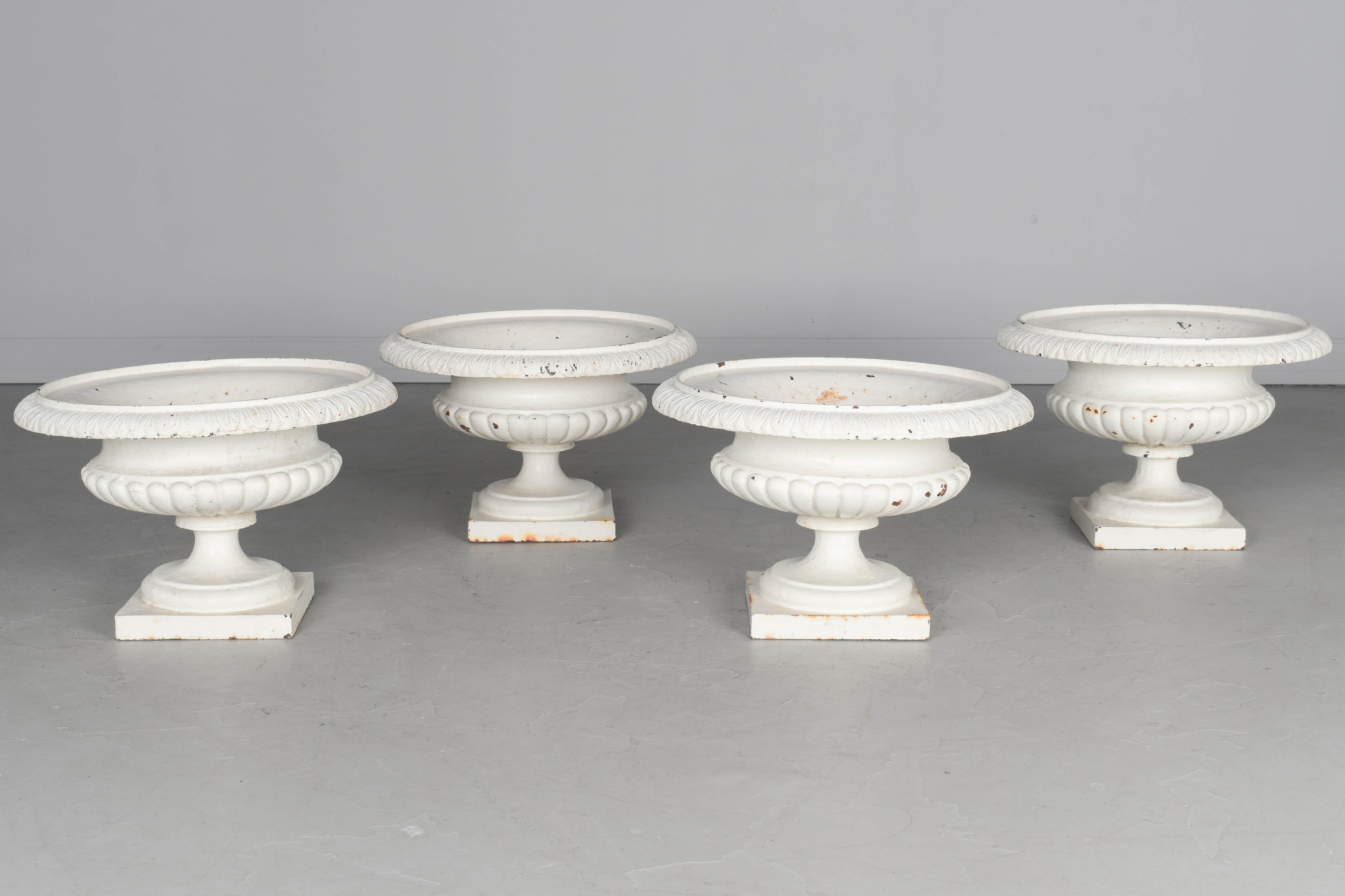 Un ensemble de quatre jardinières en fonte du 19ème siècle. Patine d'origine peinte en blanc avec de petites taches de rouille. Une urne présente un éclat à la base. Vers 1870-1880.
Dimensions : 10.5 