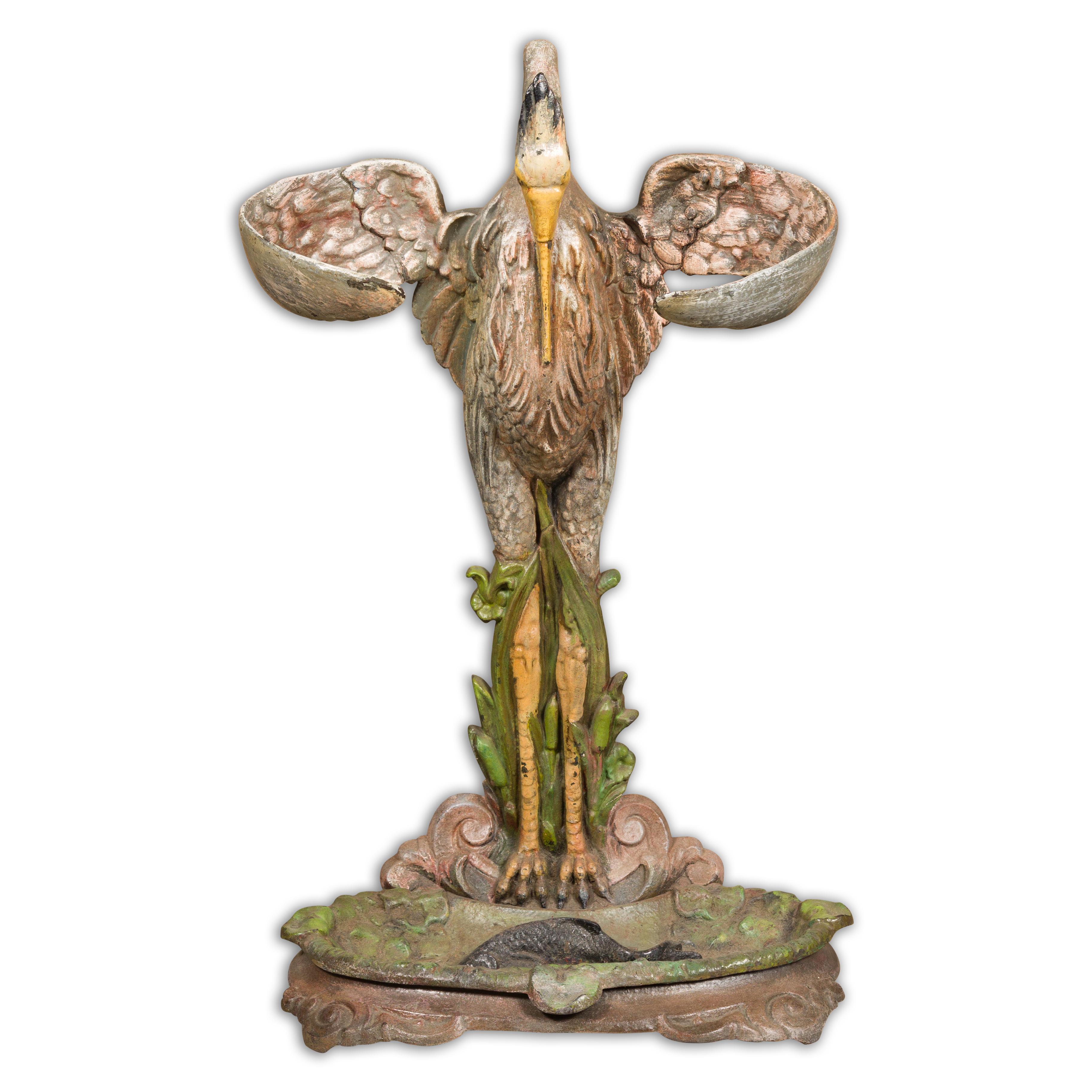 This exquisite 19th-century French cast iron heron sculpture, originally crafted as an umbrella stand, embodies a captivating blend of functionality and artistry. The heron, rendered in remarkable detail, stands poised with its wings gracefully