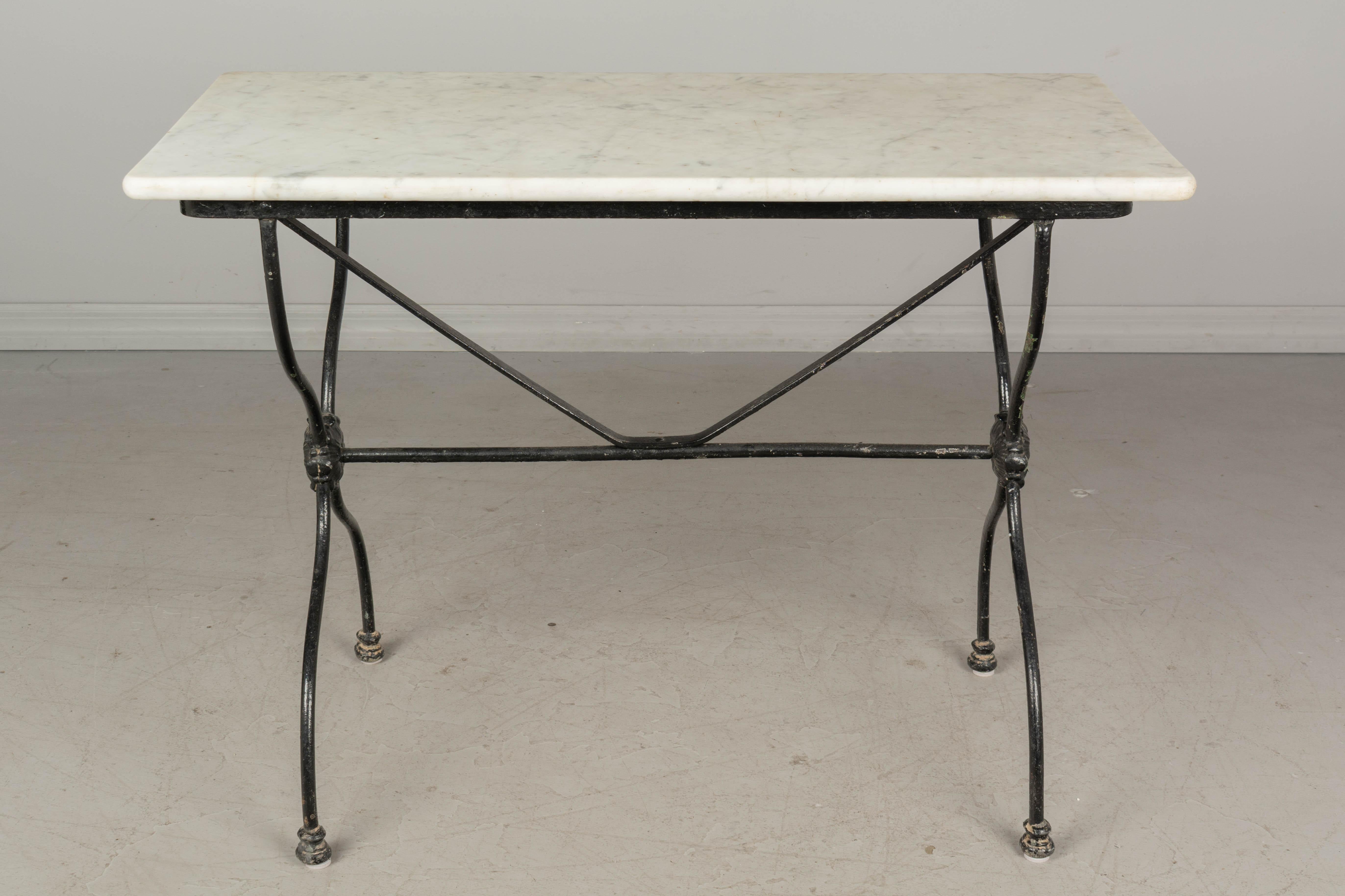 A 19th century French cast iron bistro table with black painted finish and original white veined marble top. Nice casting with rosette medallion detail. Minor paint loss. Please refer to photos for more details. Pictures are part of the
