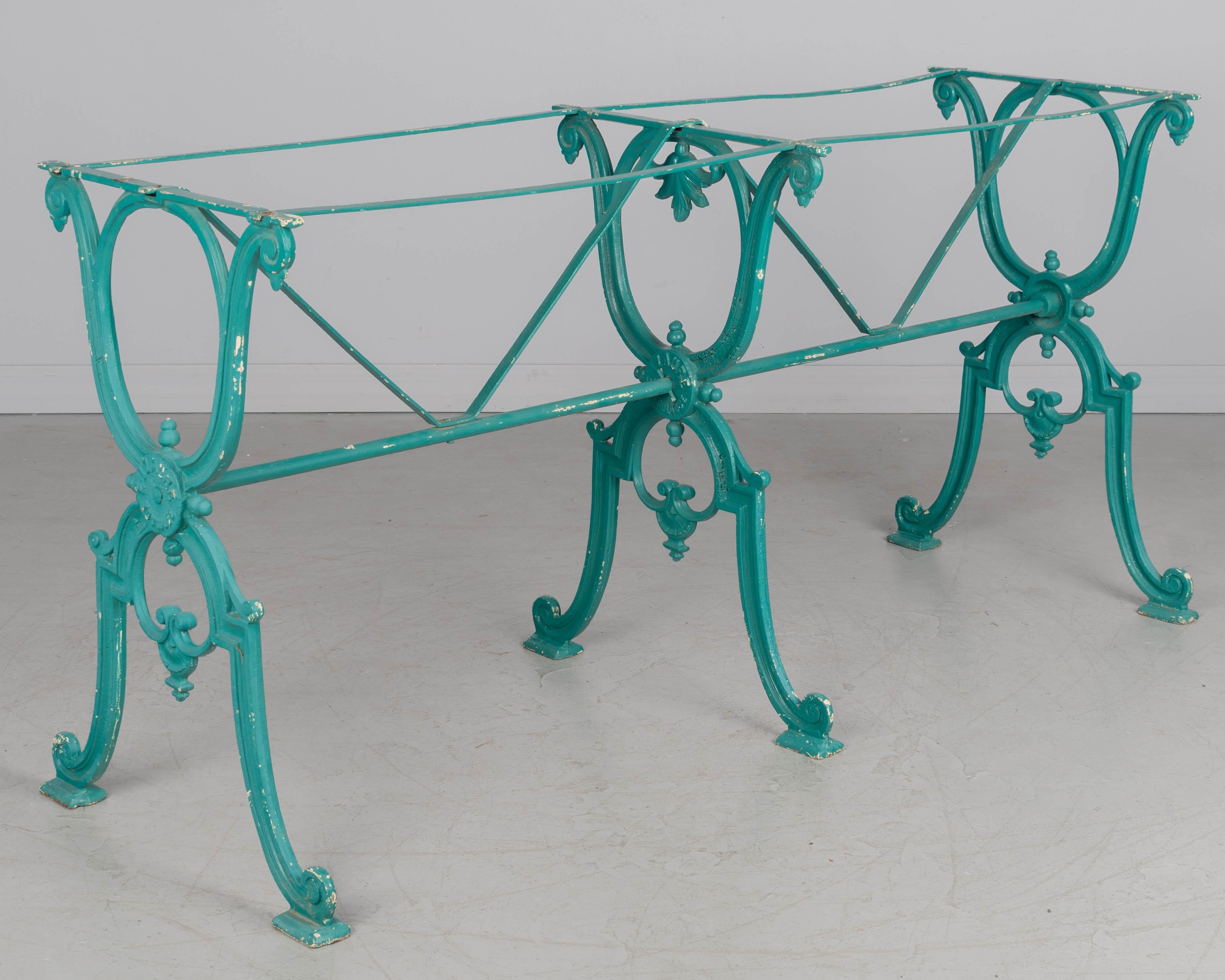 Grande base de table de bistro en fonte française du XIXe siècle, à trois pieds. La patine peinte en turquoise brillant est en bon état avec de légères pertes de peinture. Bonne qualité, fonte lourde avec cachet de la fonderie sur le médaillon