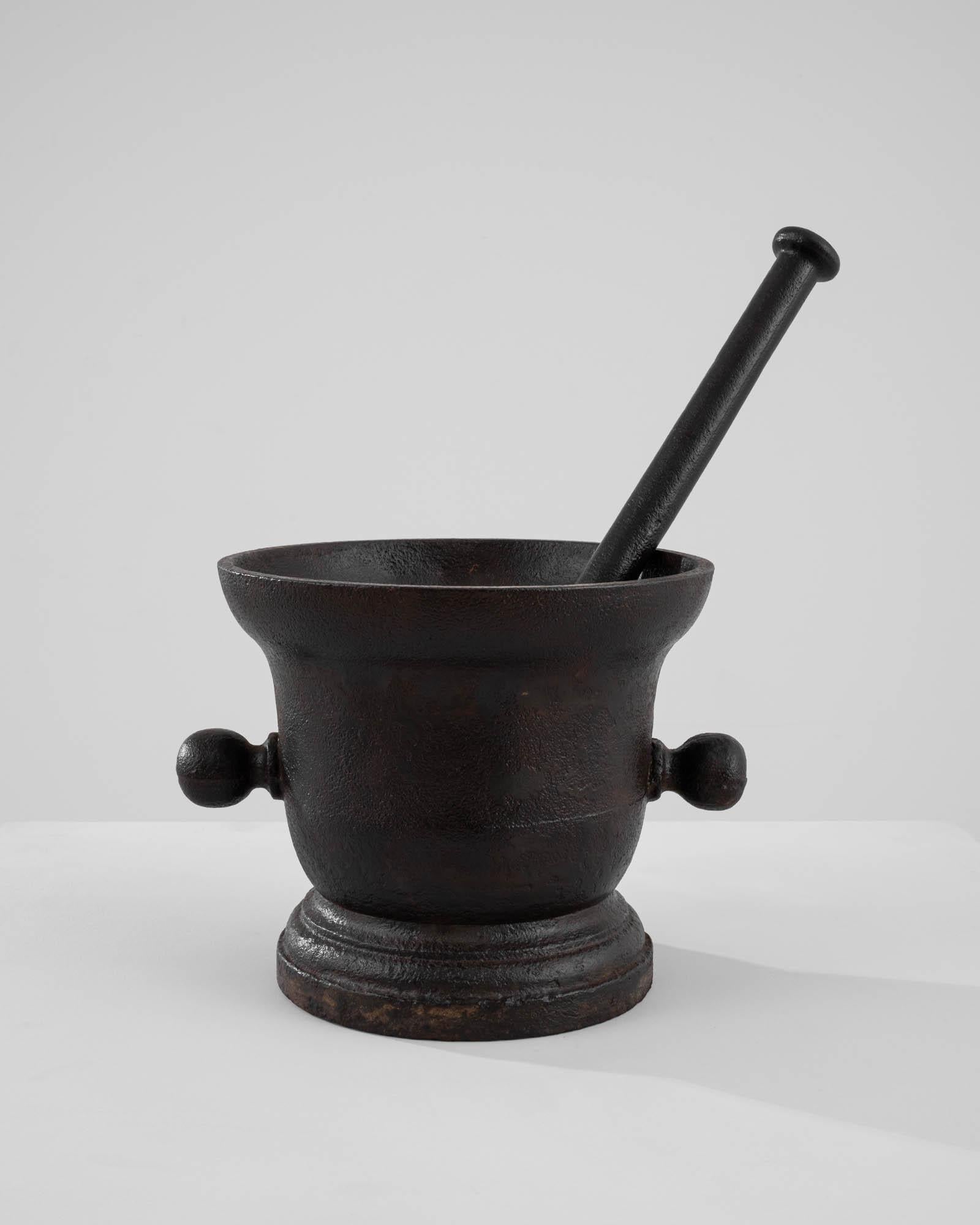 With its solid proportions and sculptural form, this antique cast iron mortar and pestle is a one of a kind find. Made in France in the 1800s, this piece would have been an integral part of a Provincial kitchen, or chemist– used for grinding spices