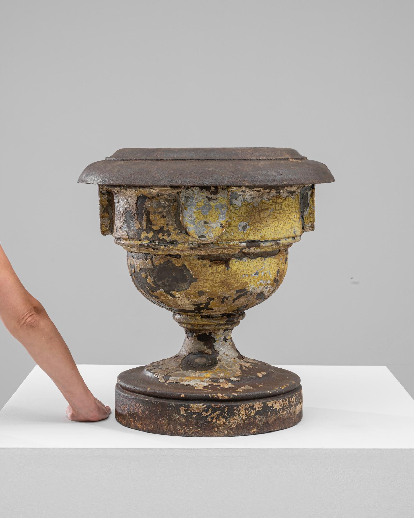 Questa fioriera in ghisa francese del XIX secolo emana un'eleganza senza tempo e un fascino rustico. La classica forma a urna presenta dettagli intricati e una patina invecchiata, con strati di vernice invecchiata e usura naturale che ne aumentano
