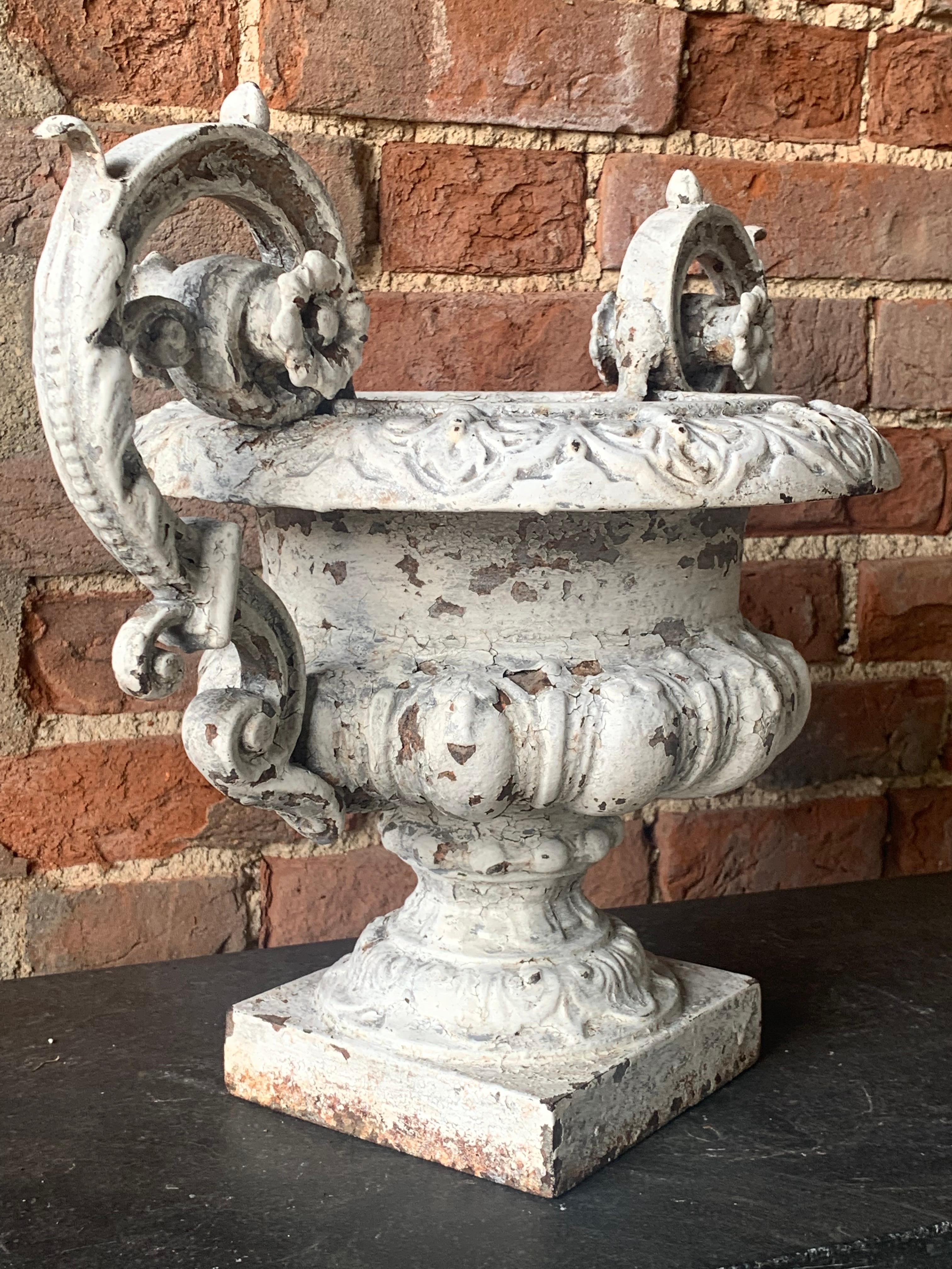 A beautiful 19th century cast iron French urn with nice original weathered paint giving it a wonderful decorative look.