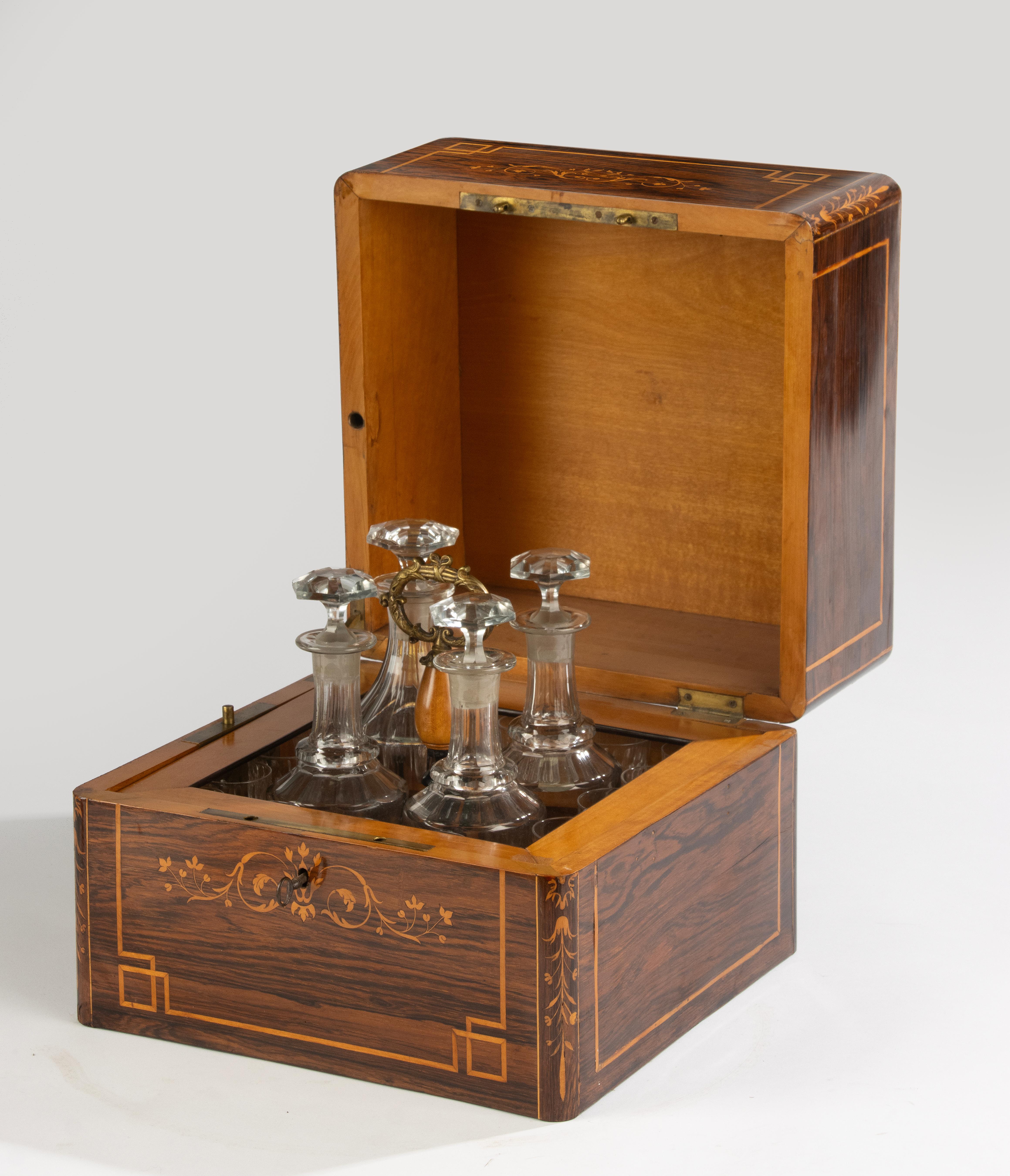 Une cave à liqueur française raffinée du XIXe siècle, magnifiquement décorée d'une marqueterie complexe dans différents bois. Le couvercle à charnière est incrusté du mot Liqueurs en écriture élégante, entouré de délicats motifs géométriques et