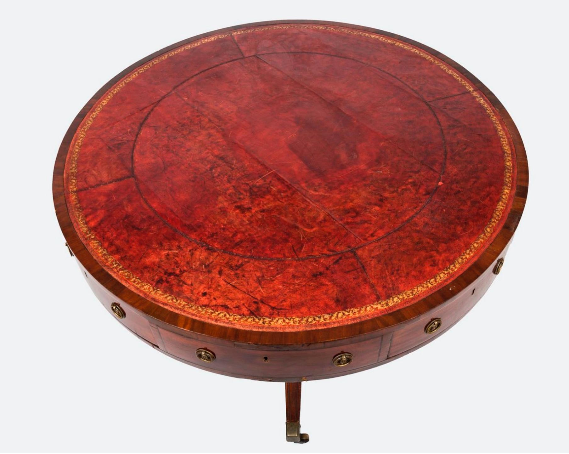 19th century antique French centre pedestal table in mahogany with aged red leather top with gold ornaments. The apron appears to have eight drawers with round brass handles (four of drawers are working and the other four are false). There is a