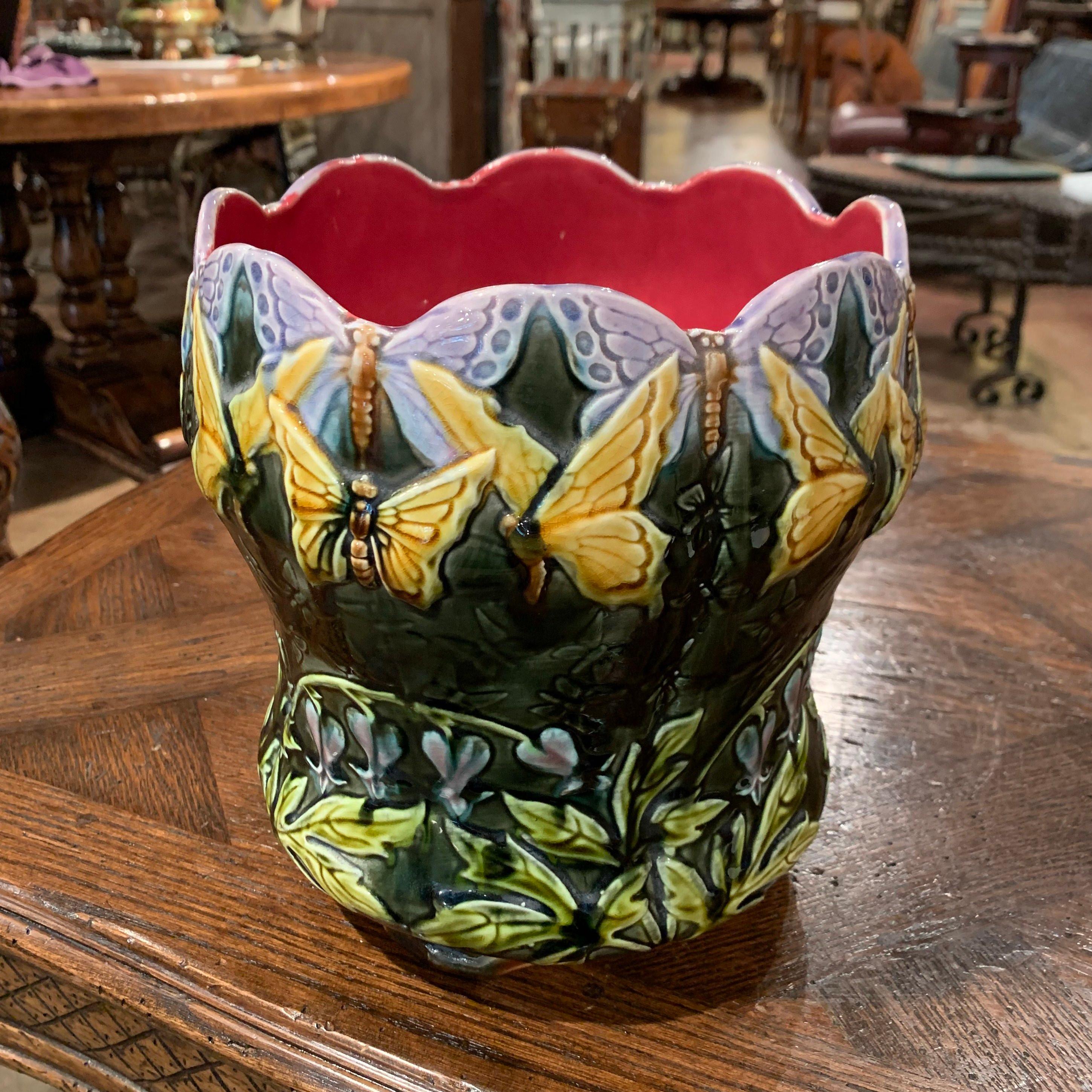 This colorful, hand painted Majolica planter was sculpted in Onnaing, France, circa 1870. Round in shape and standing on small feet, the antique cachepot embellished with scalloped edge features exquisite rendered butterfly and leaf motifs