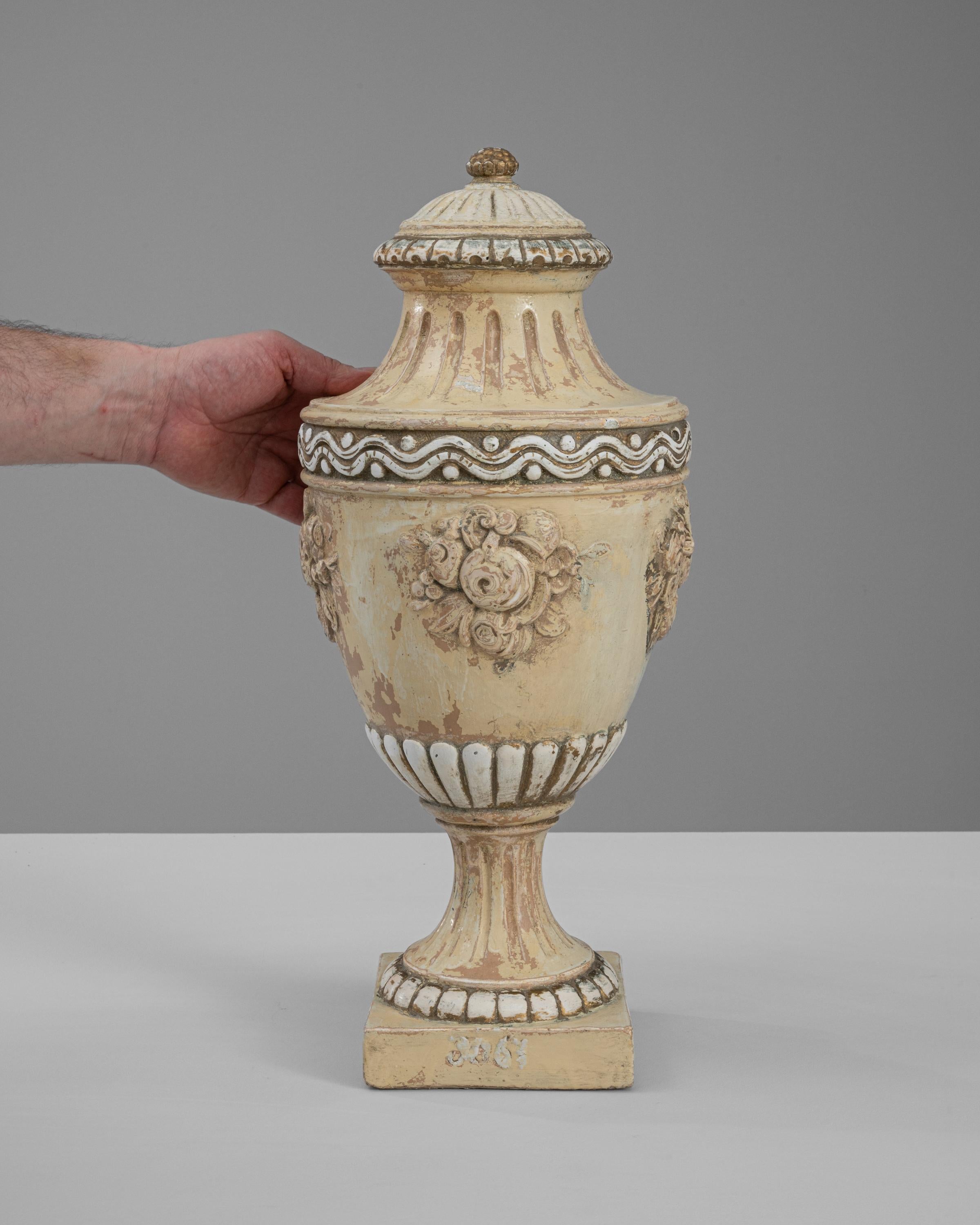 This exquisite 19th Century French Ceramic Urn is a splendid example of classic decorative art, perfect for adding an elegant touch to any setting. The urn features ornate floral motifs and intricate detailing around the base and lid, which are