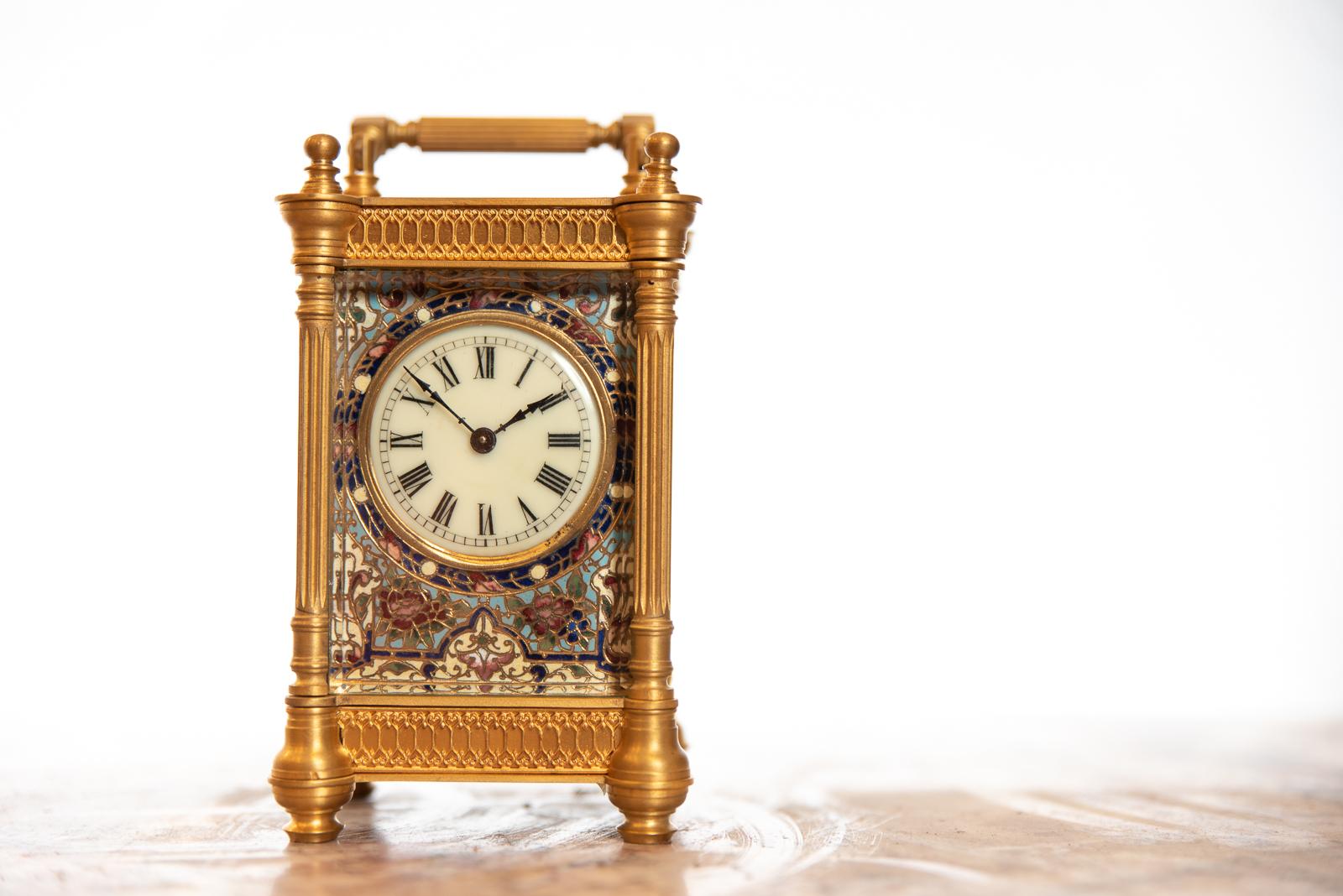 A late 19th century French Champlevé enamel timepiece carriage clock with a cream enamel dial with Roman numerals, within a guilt brass and Champlevé enamel slip. The fine 8 day timepiece movement contained in a guilt and brass and bevelled glass