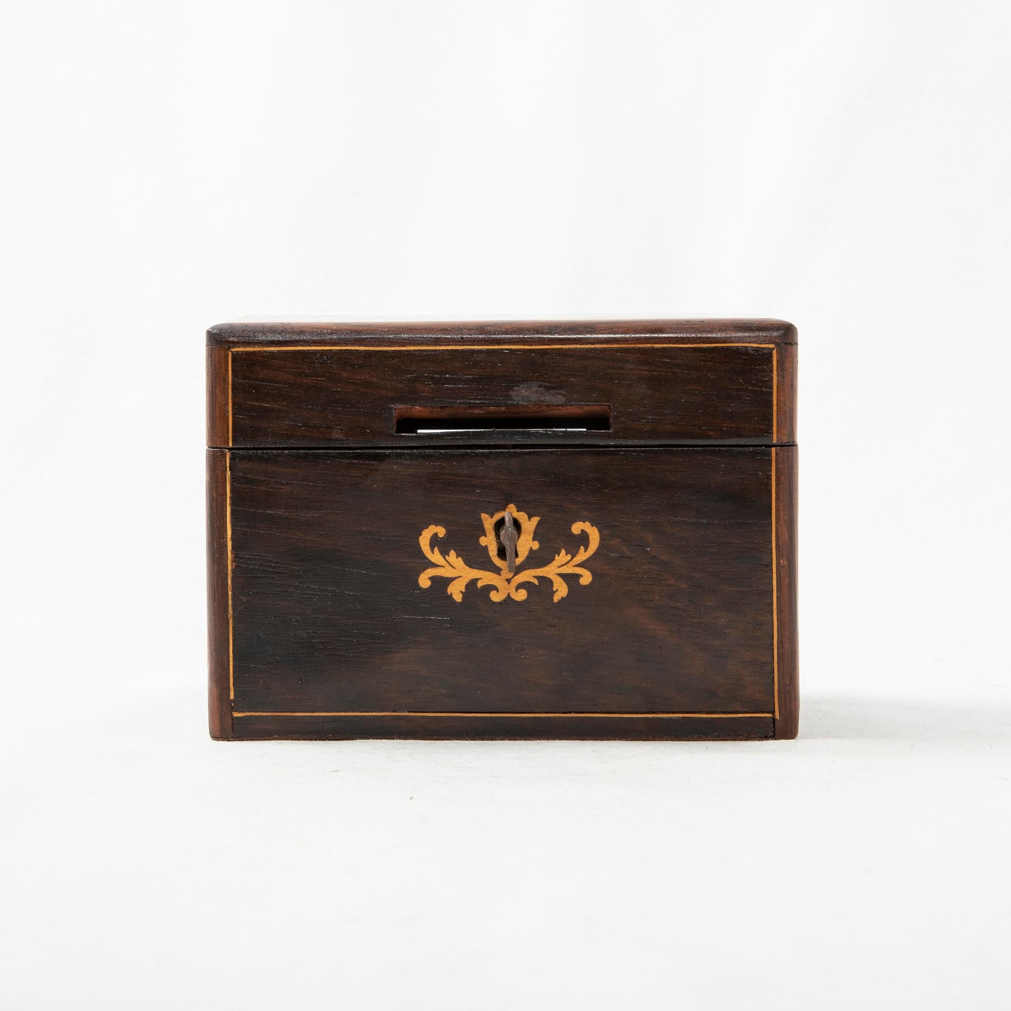 This mid-nineteenth century French Charles X period coin box is constructed of mahogany and features inlaid lemon wood borders. The lemon wood inlay on the lid reads Epargnes, or Savings in English. Intricately scrolling inlay, also in lemon wood,