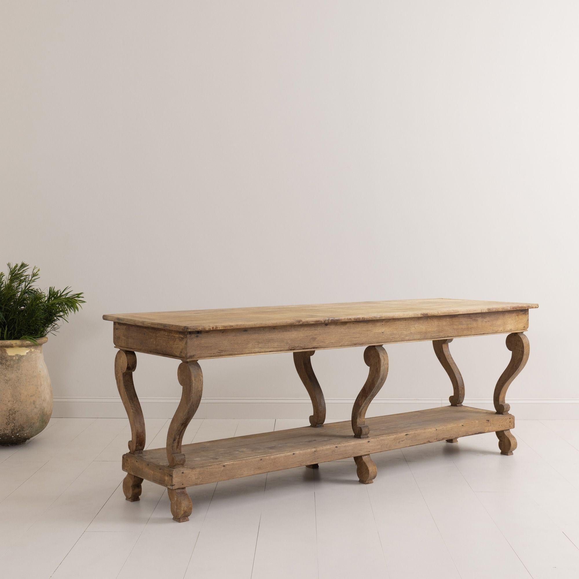 An exceptional French Charles X oak draper's table from the Restoration period in its original natural patina with decorative volute details.  This piece would make a lovely kitchen island or console table or bathroom vanity.  Found in the village