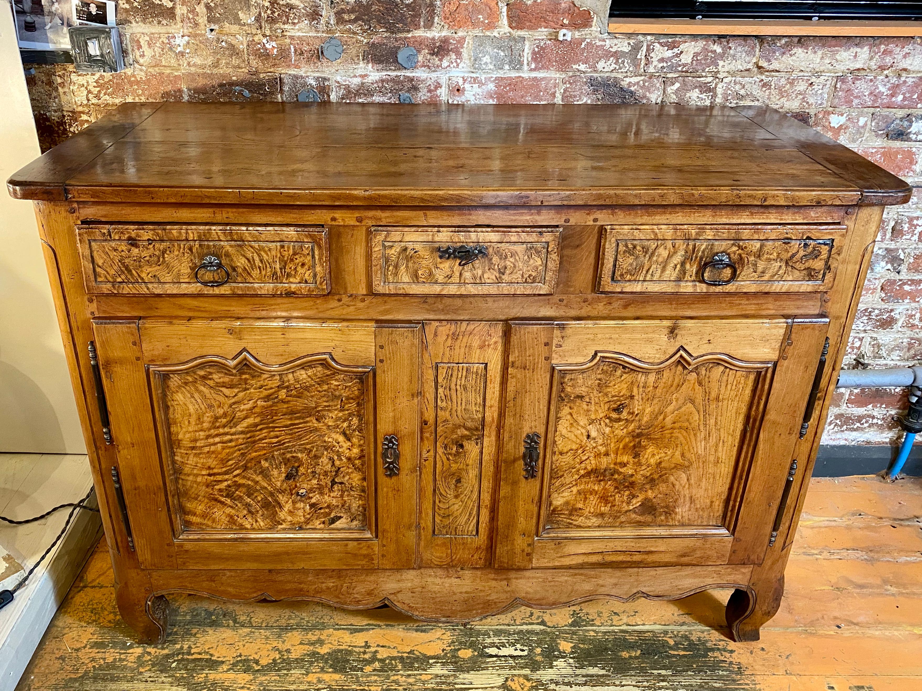 A strikingly beautiful and very practical early 19th century French cherry and elm buffet with three drawers over two cupboard doors. Original ironware. Excellent color and patina.
This piece would look great in a kitchen, hallway or living area.