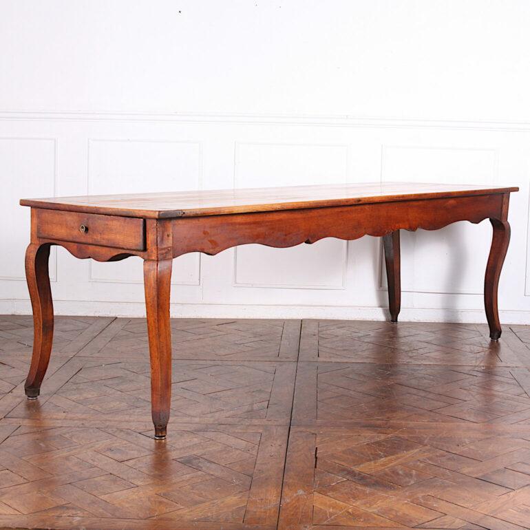 Rustic French cherrywood farm table with lovely patina, unusually long and with a drawer in one end and a pull-out breadboard at the other. Scalloped apron and elegant cabriole legs.
A charming and functional mid-19th century table to seat 10