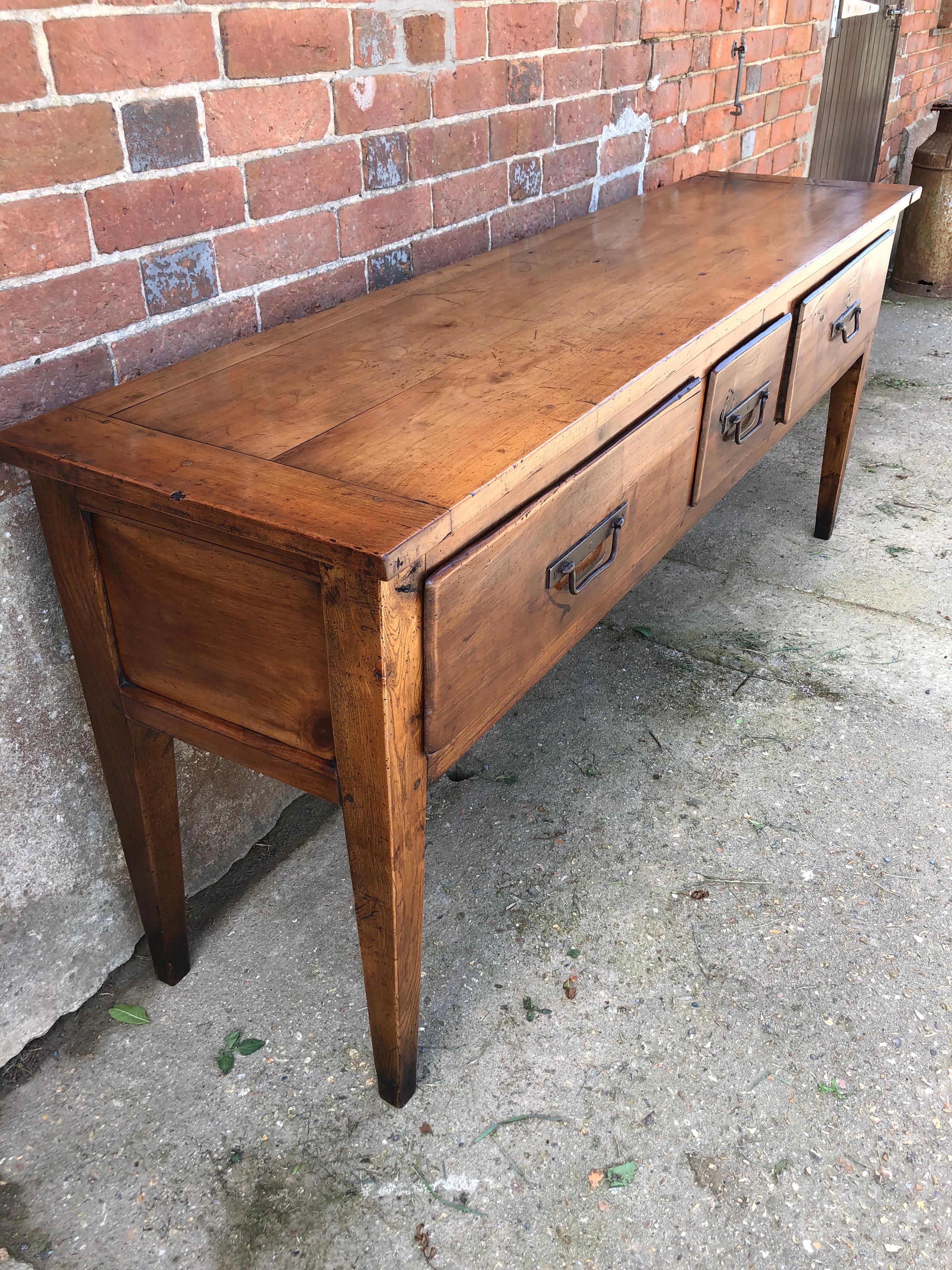 Very handsome 19th century three-drawer cherrywood server with original ironwork handles. This Item has been restored, re-polished and given a practical, hard wearing finish by one of the UK's top furniture conservators.
