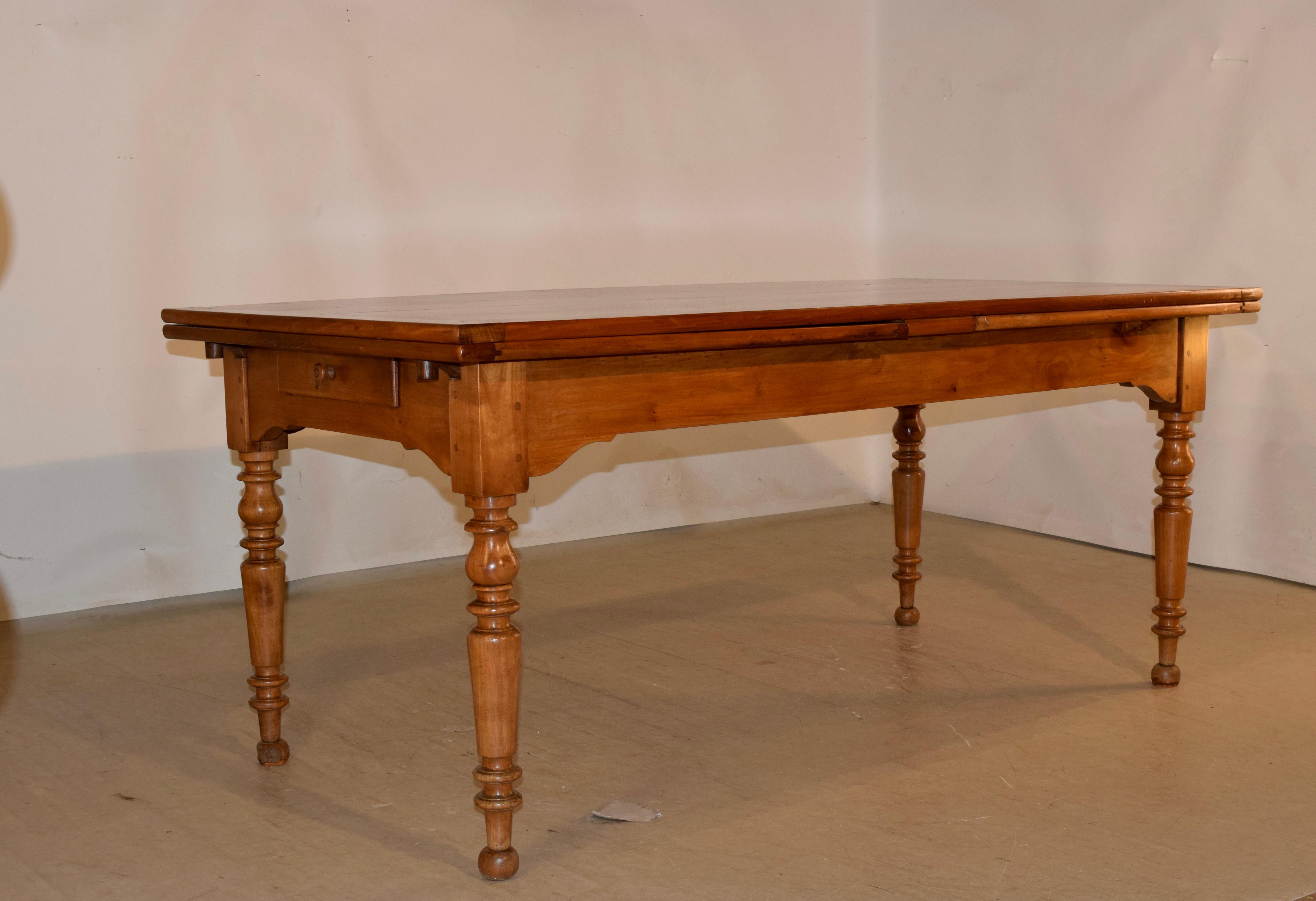 19th century cherry farm table from France which has double draw leaves. The cherry is a gorgeous color with wonderful patina. This fabulous table is handy for any space, since it can extend into a large table. The top is made from four boards, with