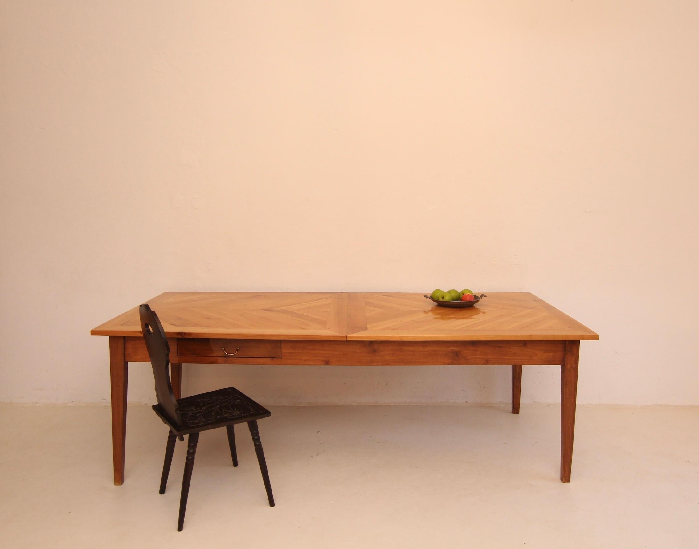 Une belle table de campagne française de la 2e moitié du 19e siècle. Fabriqué en bois de cerisier massif.

Composée de 4 pieds carrés effilés, d'un cadre avec tiroir, et d'un plateau de table en saillie sur tout le pourtour, avec un parquet à motif